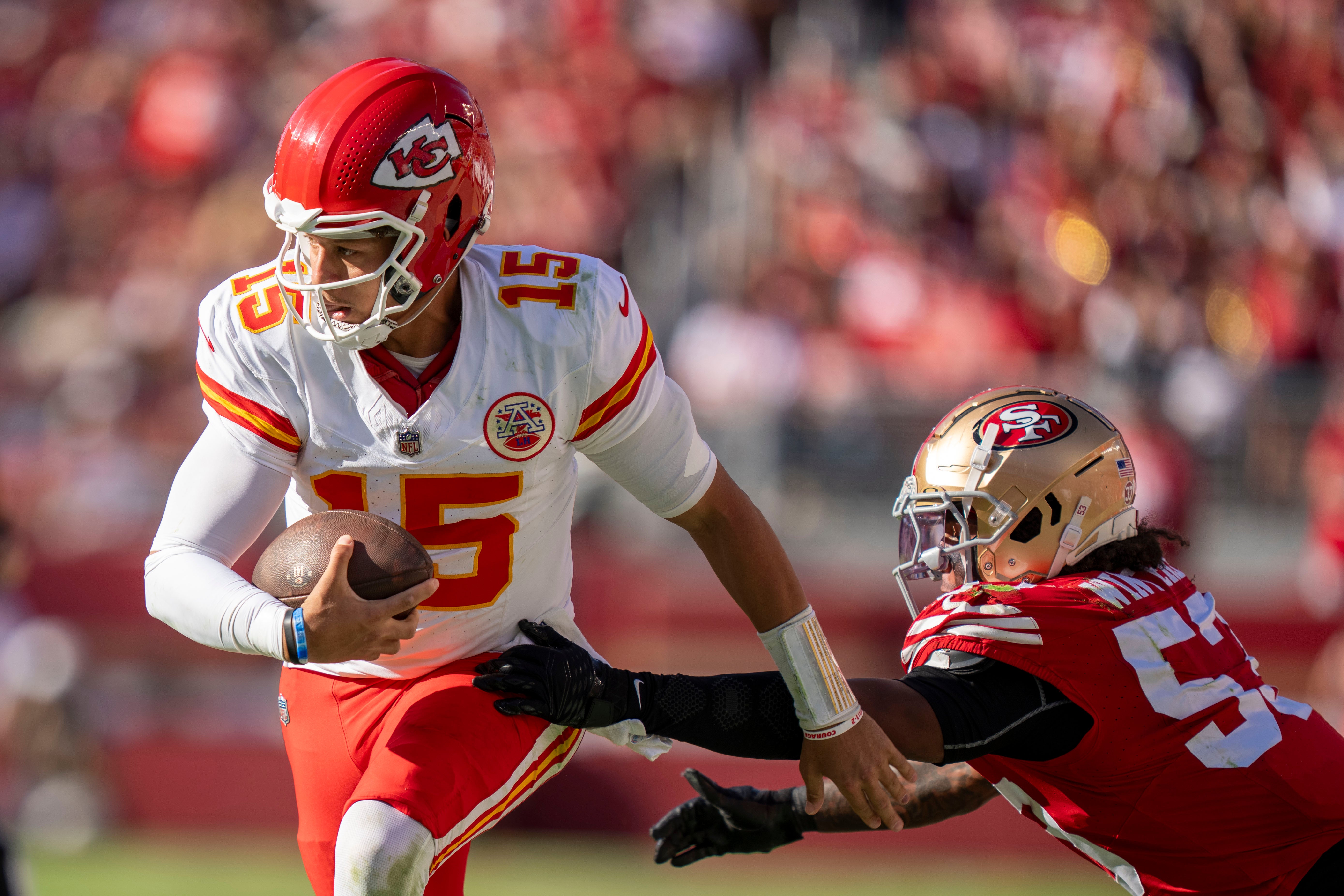 Kansas City Chiefs quarterback Patrick Mahomes (15) runs past San Francisco 49ers linebacker Dee Winters (53) during the third quarter at Levi's Stadium.
