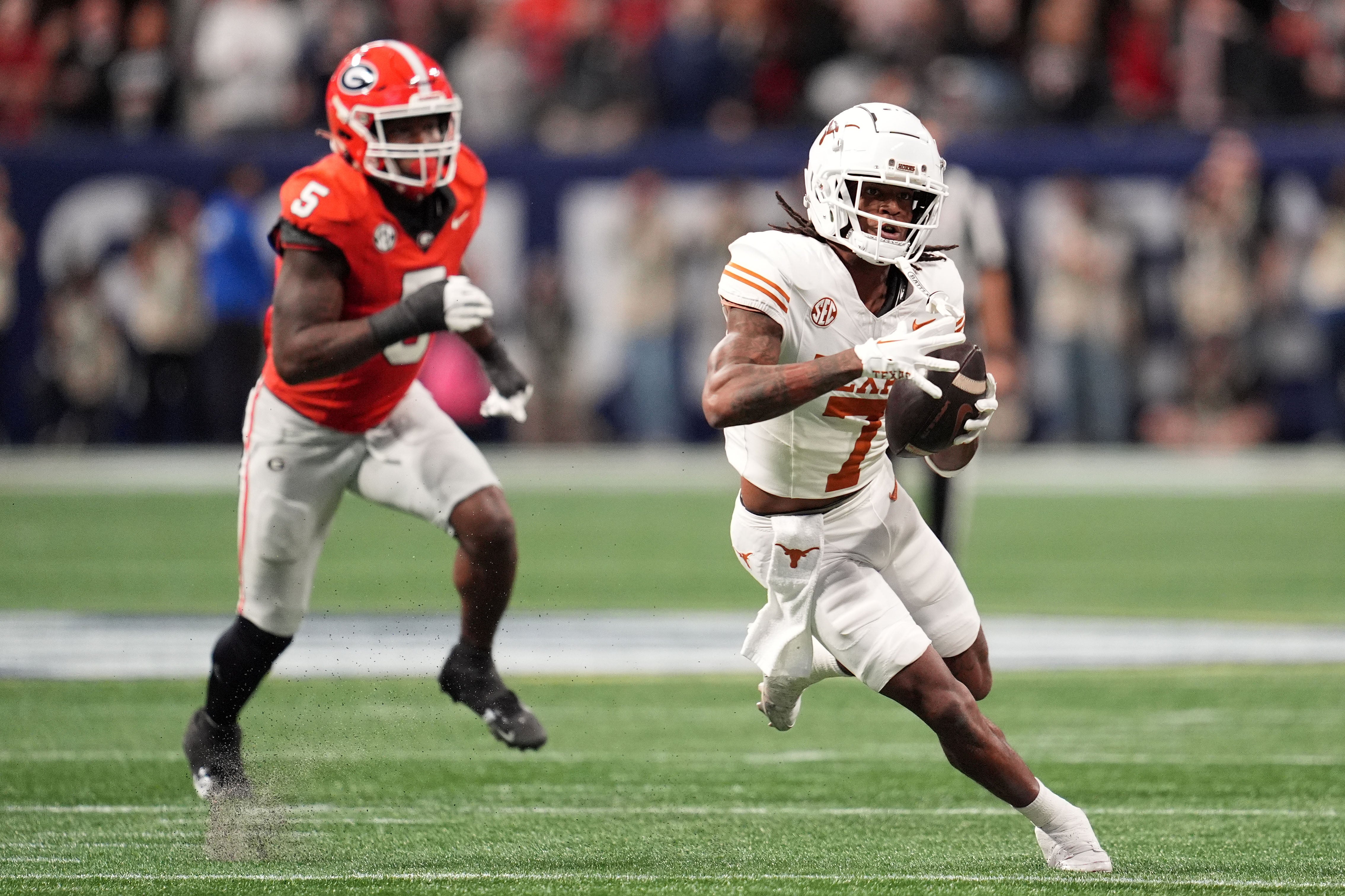 Texas Longhorns wide receiver Isaiah Bond (7) makes a catch past Georgia Bulldogs linebacker Raylen Wilson (5) during the first half in the 2024 SEC Championship game at Mercedes-Benz Stadium.