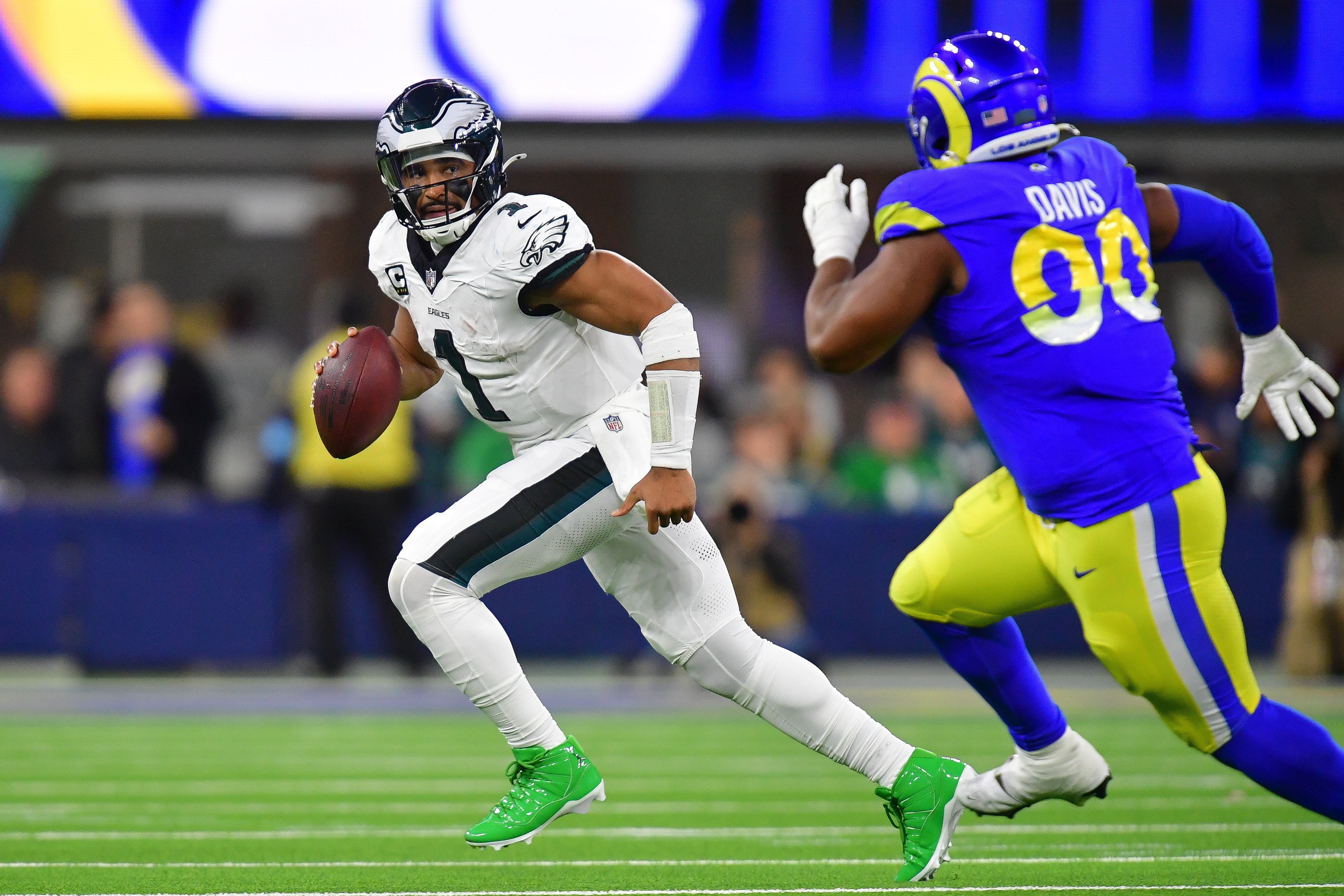 Philadelphia Eagles quarterback Jalen Hurts (1) runs the ball ahead of Los Angeles Rams defensive tackle Tyler Davis (90) during the second half at SoFi Stadium.
