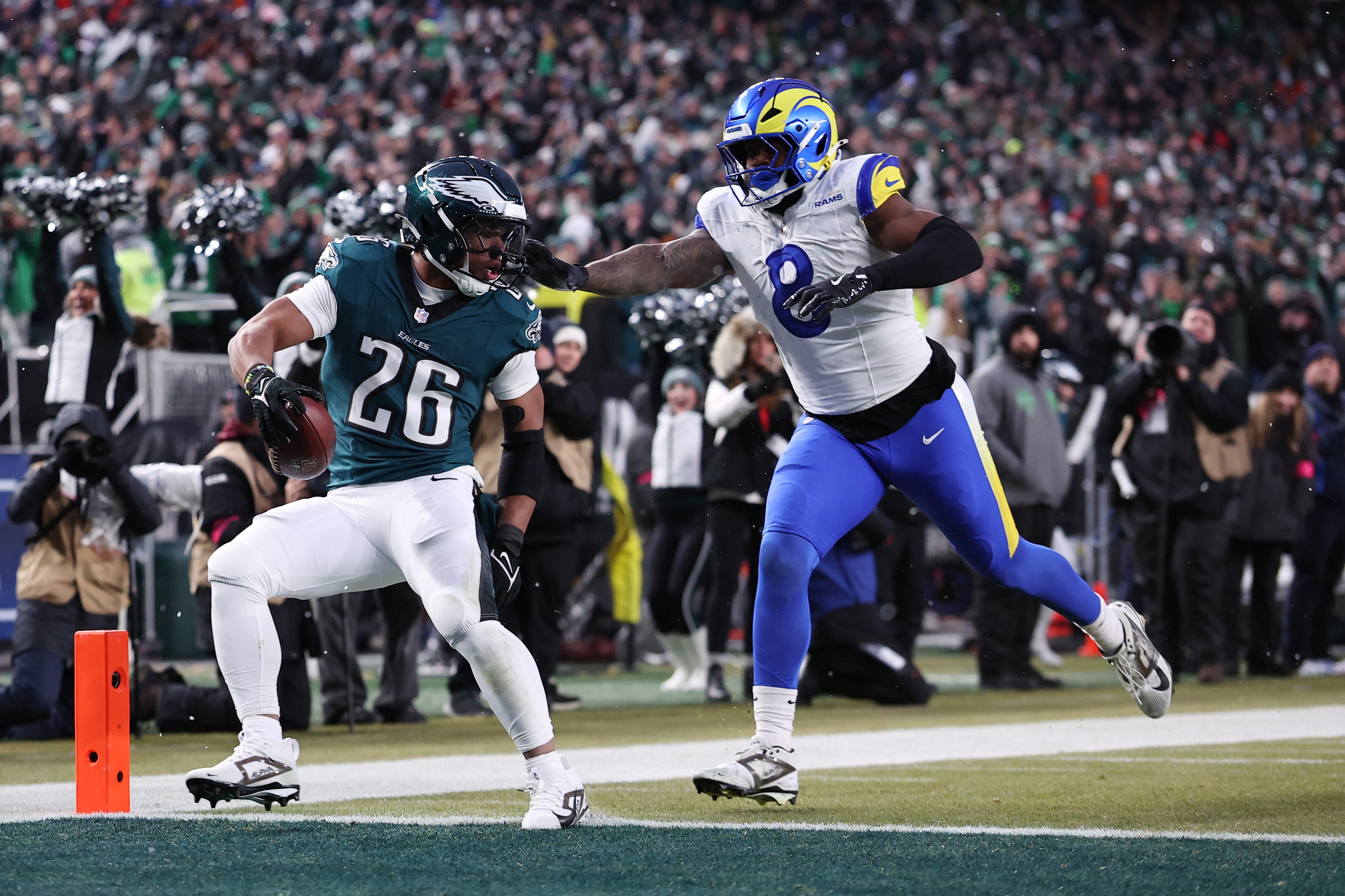 Philadelphia Eagles running back Saquon Barkley (26) scores a touchdown past Los Angeles Rams linebacker Jared Verse (8) in the first half in a 2025 NFC divisional round game at Lincoln Financial Field.