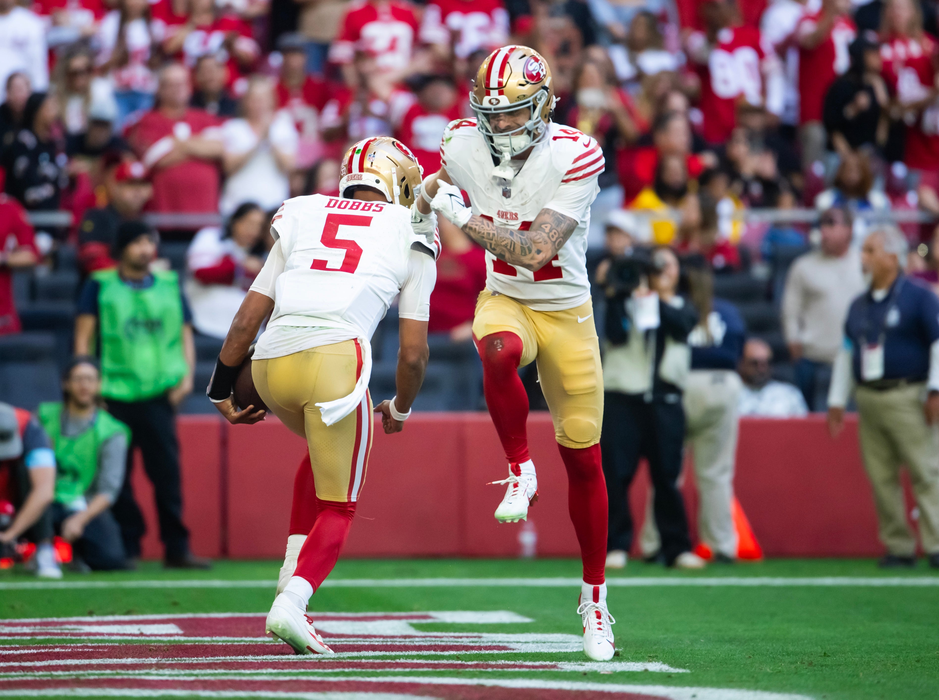 San Francisco 49ers quarterback Joshua Dobbs (5) celebrates a touchdown with wide receiver Ricky Pearsall (14) against the Arizona Cardinals in the first half at State Farm Stadium.