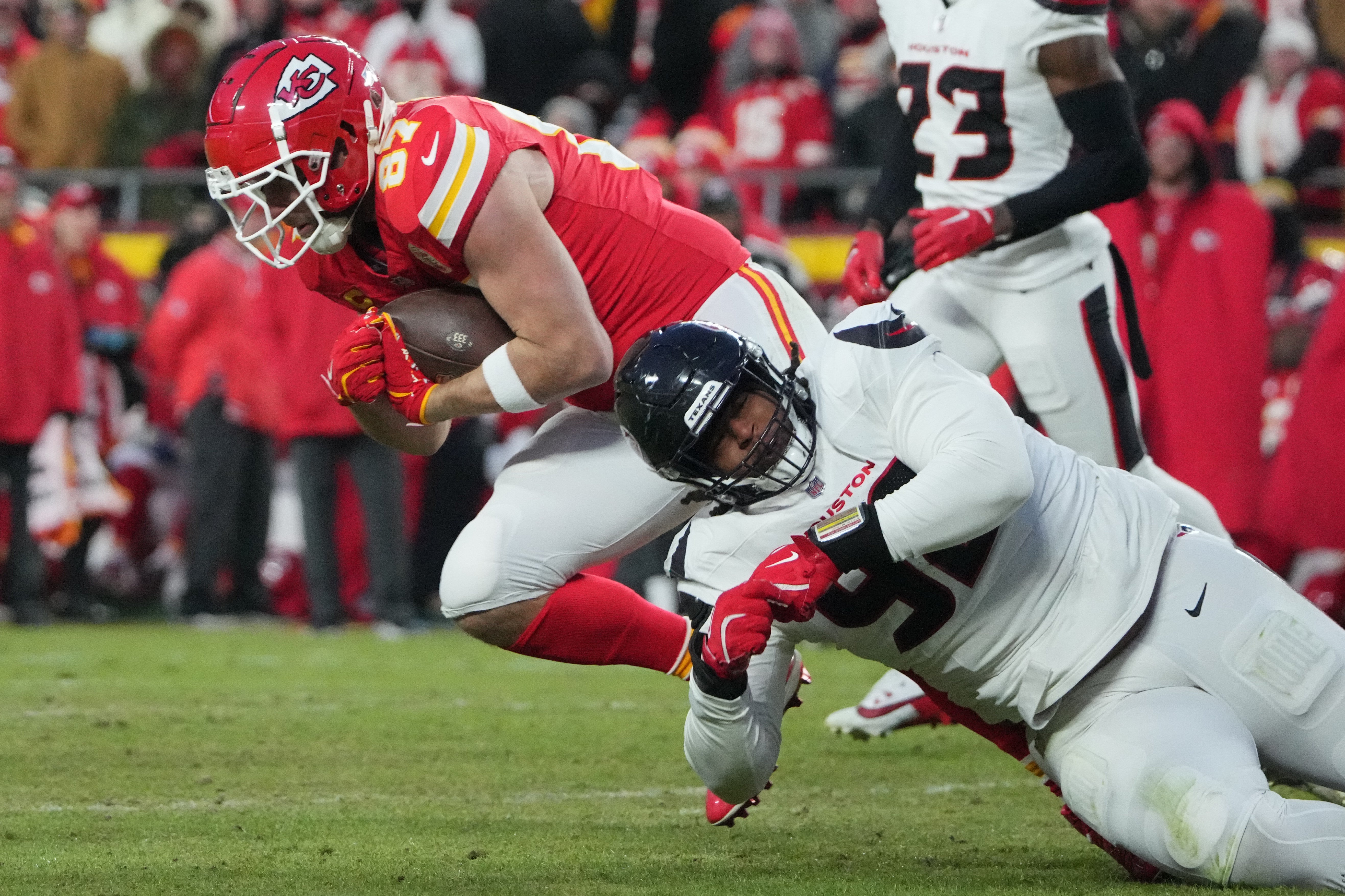 Jan 18, 2025; Kansas City, Missouri, USA; Kansas City Chiefs tight end Travis Kelce (87) runs the ball against Houston Texans defensive end Dylan Horton (92) during the fourth quarter of a 2025 AFC divisional round game at GEHA Field at Arrowhead Stadium.