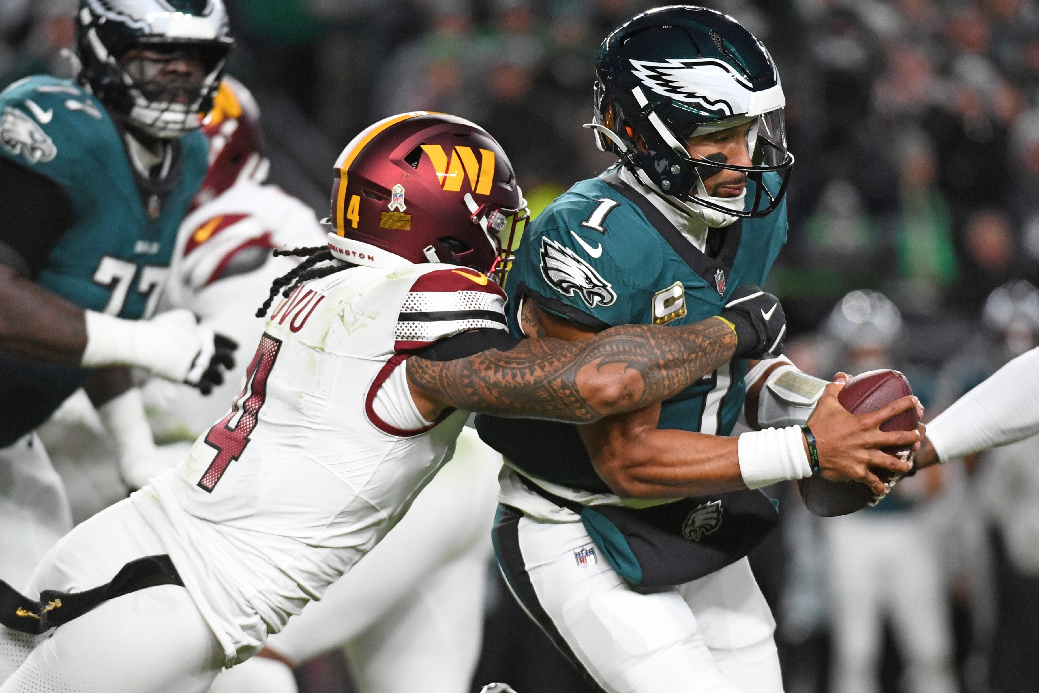 Nov 14, 2024; Philadelphia, Pennsylvania, USA; Philadelphia Eagles quarterback Jalen Hurts (1) is sacked by Washington Commanders linebacker Frankie Luvu (4) during the first quarter at Lincoln Financial Field.