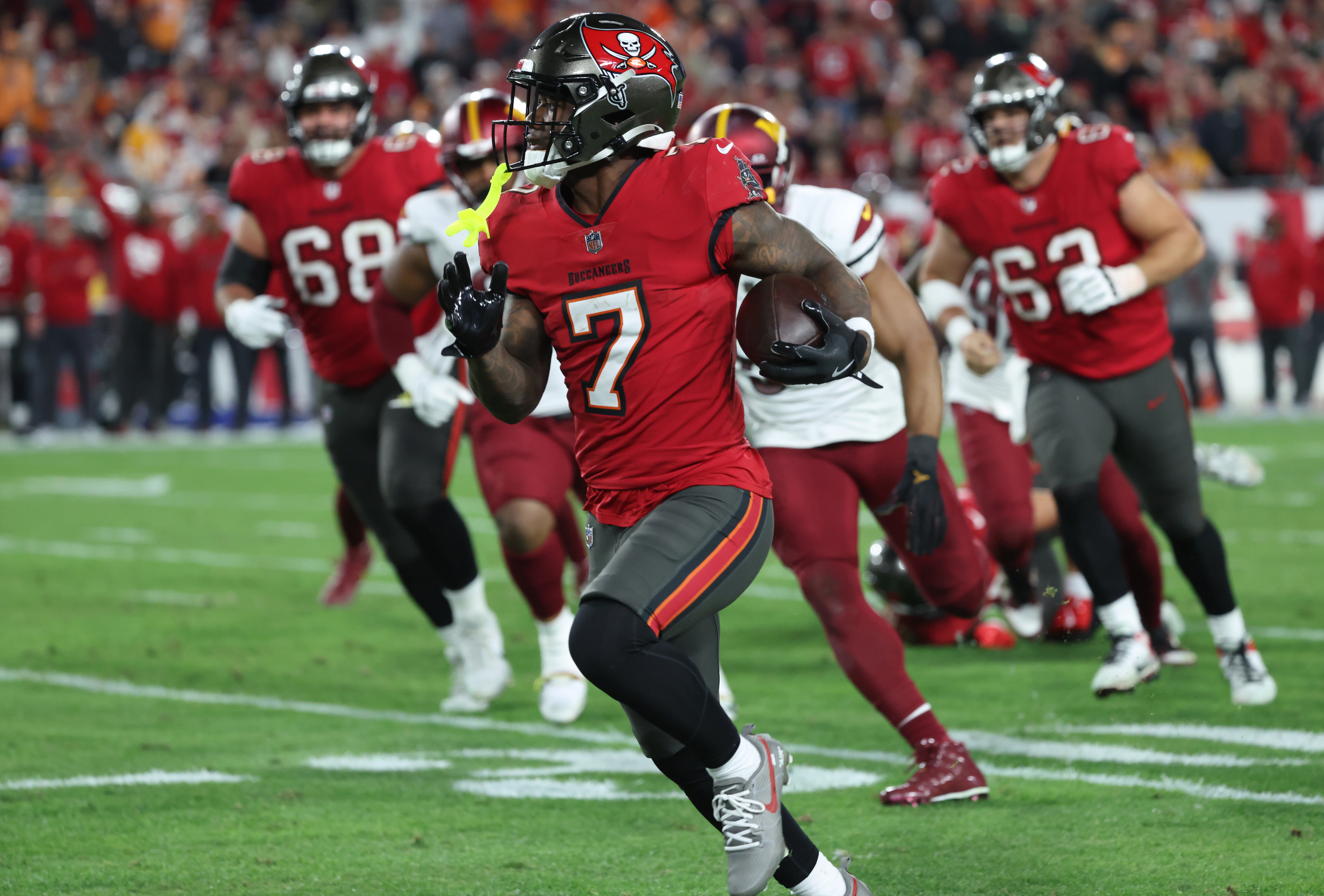 Jan 12, 2025; Tampa, Florida, USA; Tampa Bay Buccaneers running back Bucky Irving (7) runs during the third quarter of a NFC wild card playoff against the Washington Commanders at Raymond James Stadium.