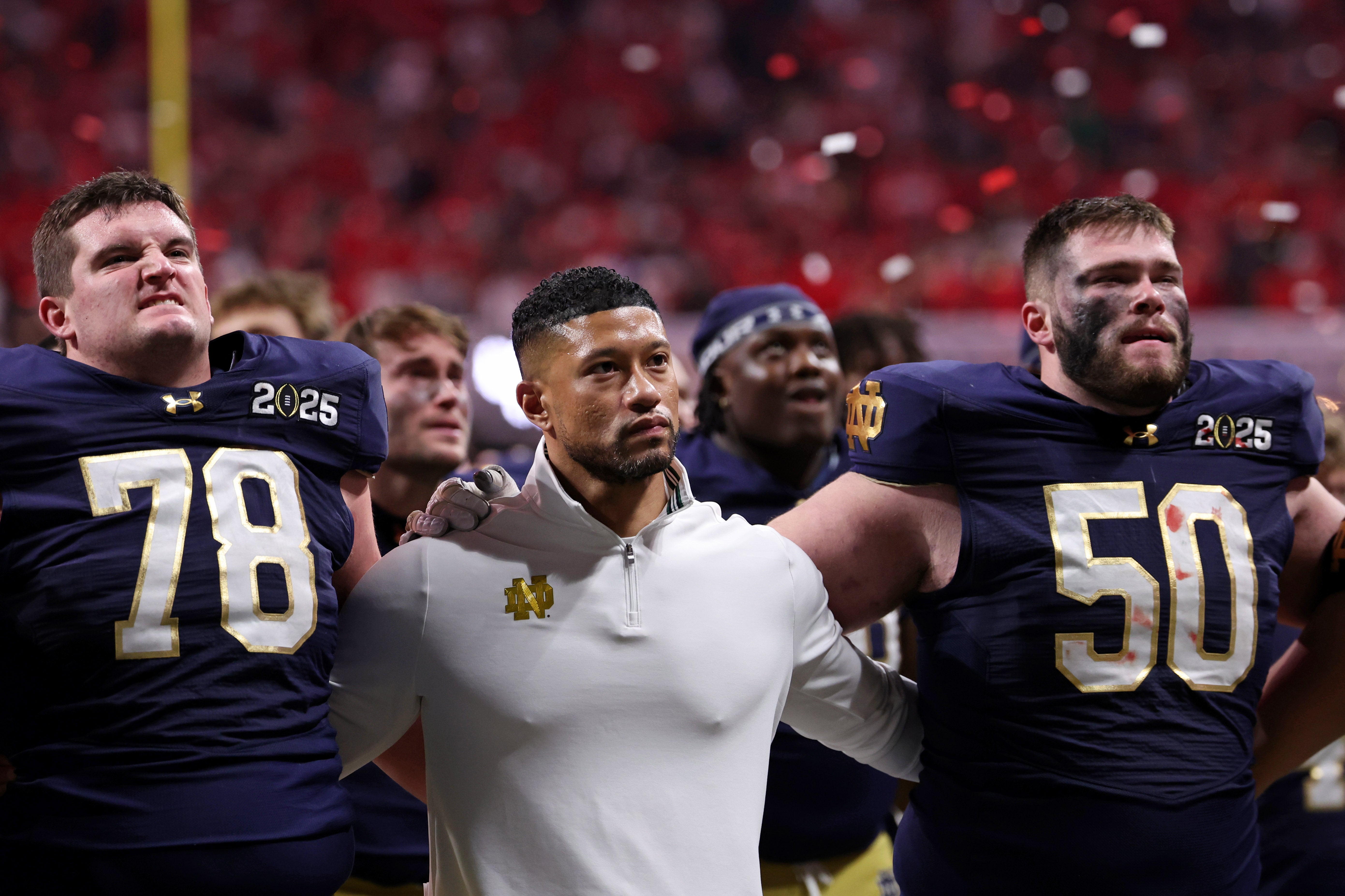 Notre Dame Fighting Irish offensive lineman Pat Coogan (78), head coach Marcus Freeman, and offensive lineman Rocco Spindler (50) react after losing against the Ohio State Buckeyes in the CFP National Championship college football game at Mercedes-Benz Stadium.