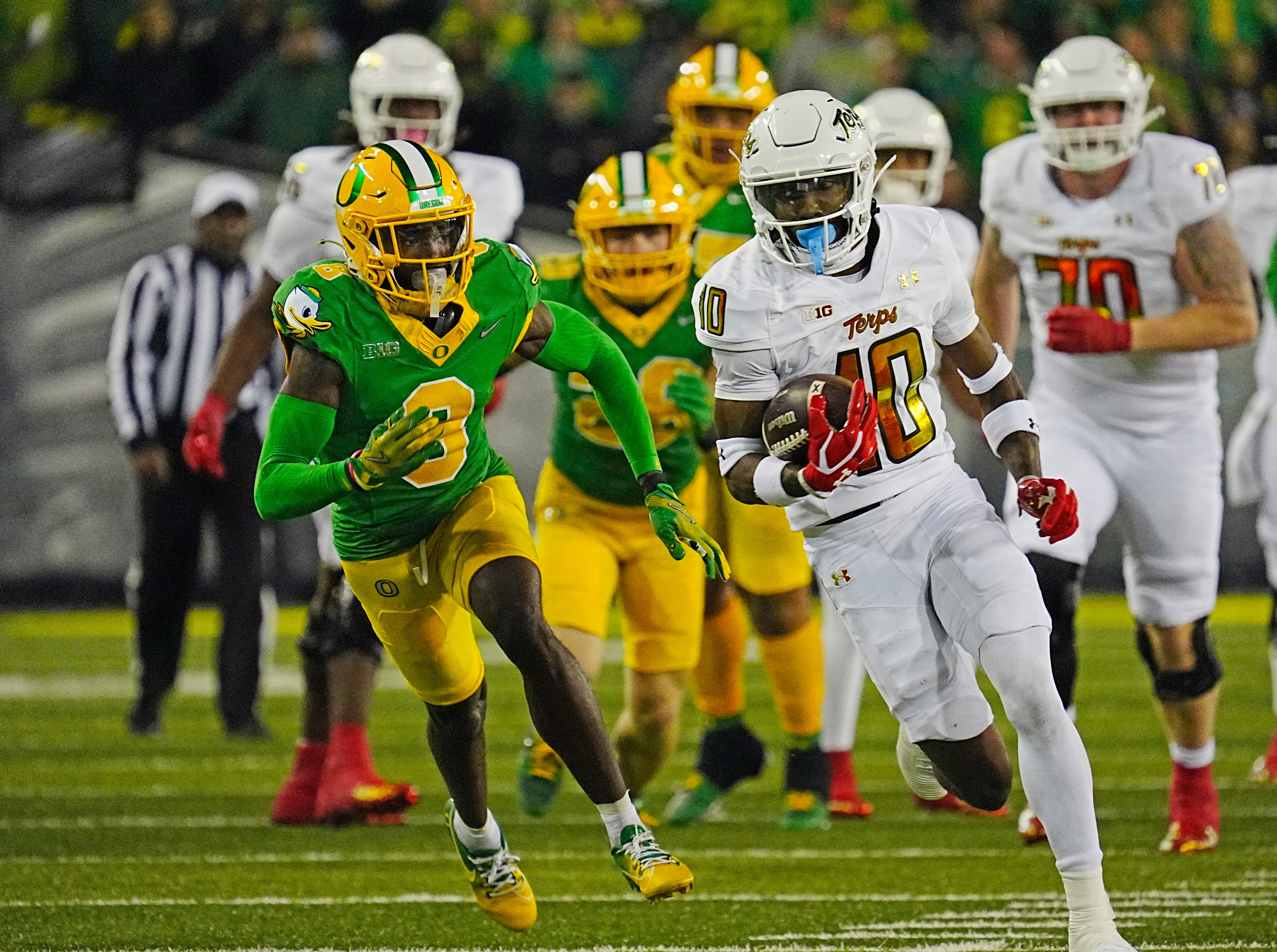 Maryland’s Tai Felton, right, runs away from Oregon’s Brandon Johnson, left, during the third quarter at Autzen Stadium.
