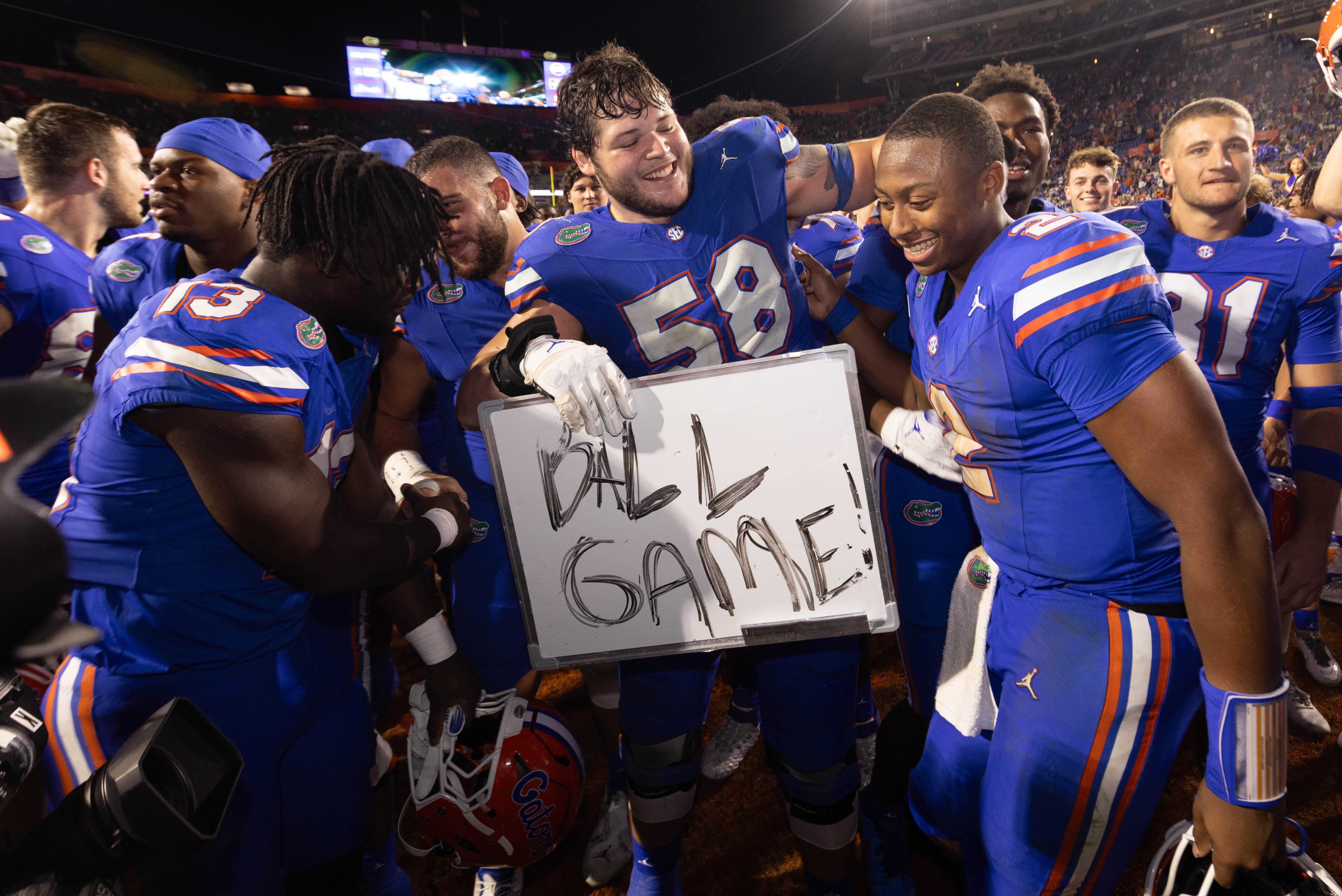 Florida Gators offensive lineman Austin Barber (58) pulls in Florida Gators quarterback DJ Lagway (2) as the Gators celebrated at Ben Hill Griffin Stadium in Gainesville, FL on Saturday, November 16, 2024. The Gators defeated the Tigers 27-16.