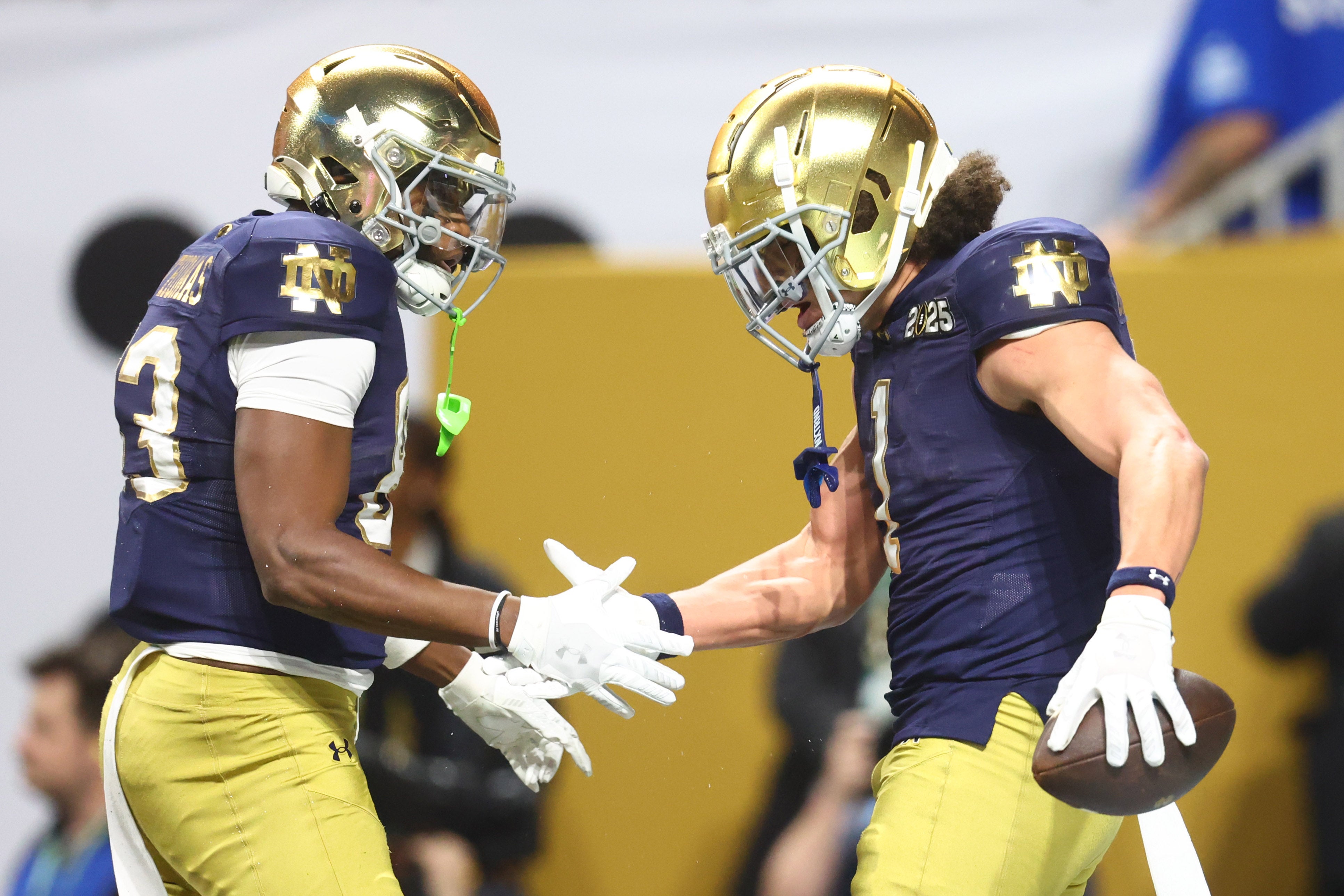 Notre Dame Fighting Irish wide receiver Jayden Thomas (83) high fives wide receiver Jaden Greathouse (1) after a touchdown against the Ohio State Buckeyes during the second half the CFP National Championship college football game at Mercedes-Benz Stadium.