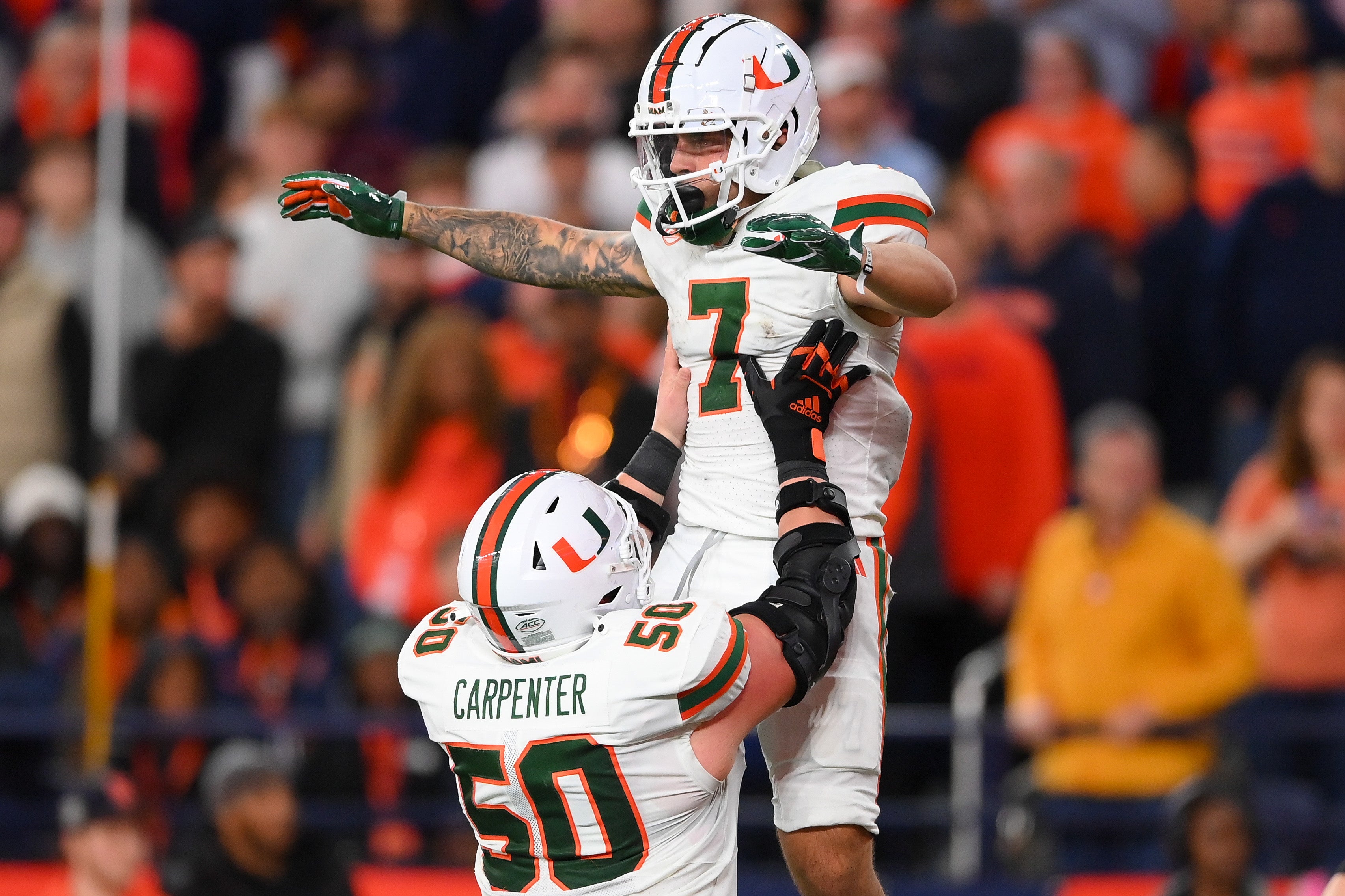 Nov 30, 2024; Syracuse, New York, USA; Miami Hurricanes wide receiver Xavier Restrepo (7) celebrates an offensive play with teammate center Zach Carpenter (50) against the Syracuse Orange during the second half at the JMA Wireless Dome.