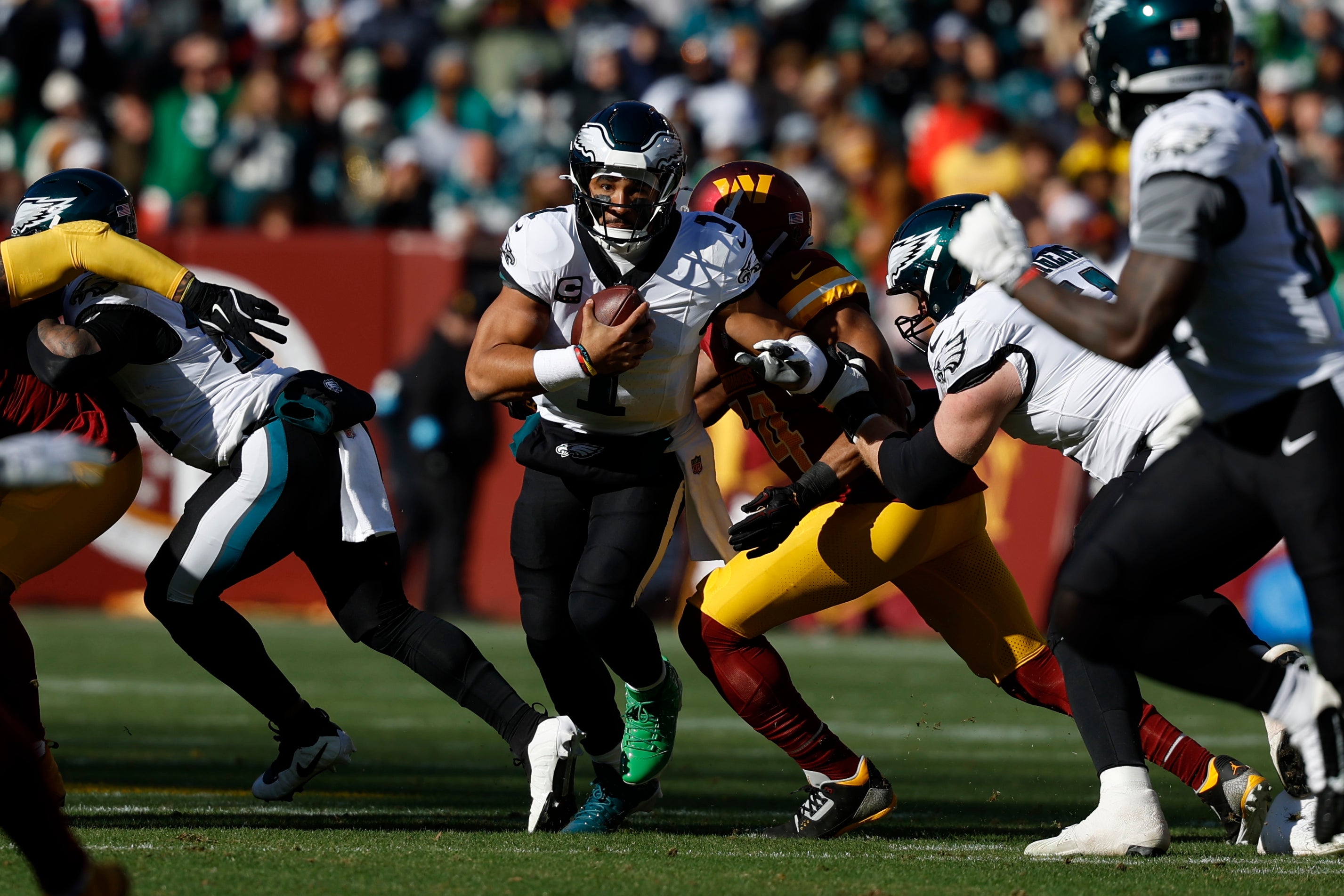 Philadelphia Eagles quarterback Jalen Hurts (1) runs with the ball past Washington Commanders linebacker Bobby Wagner (54) during the first quarter at Northwest Stadium.