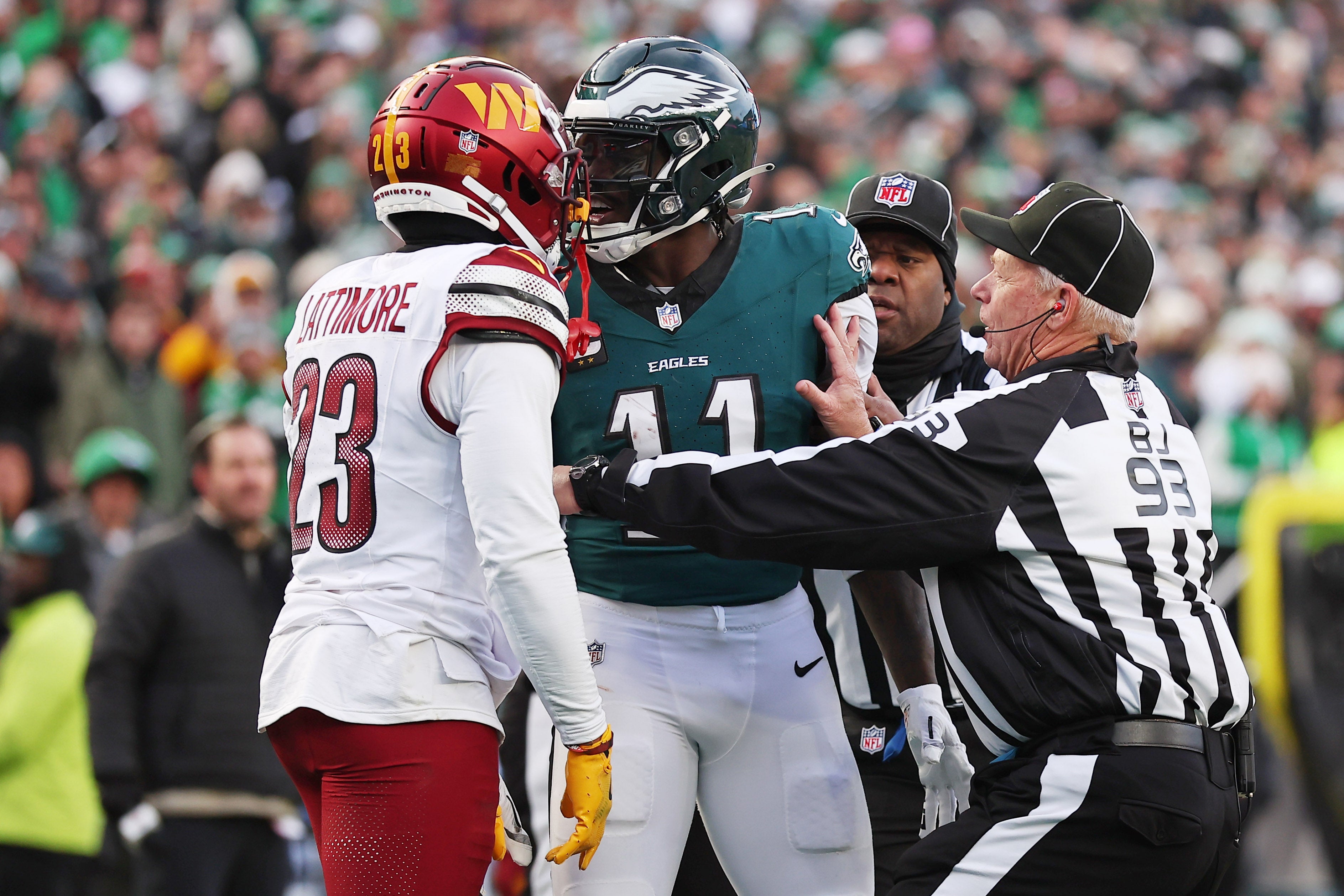 Jan 26, 2025; Philadelphia, PA, USA; Philadelphia Eagles quarterback Jalen Hurts (1) talks with Washington Commanders cornerback Marshon Lattimore (23) as back judge Scott Helverson (93) trie to break them up during the first half in the NFC Championship game at Lincoln Financial Field.