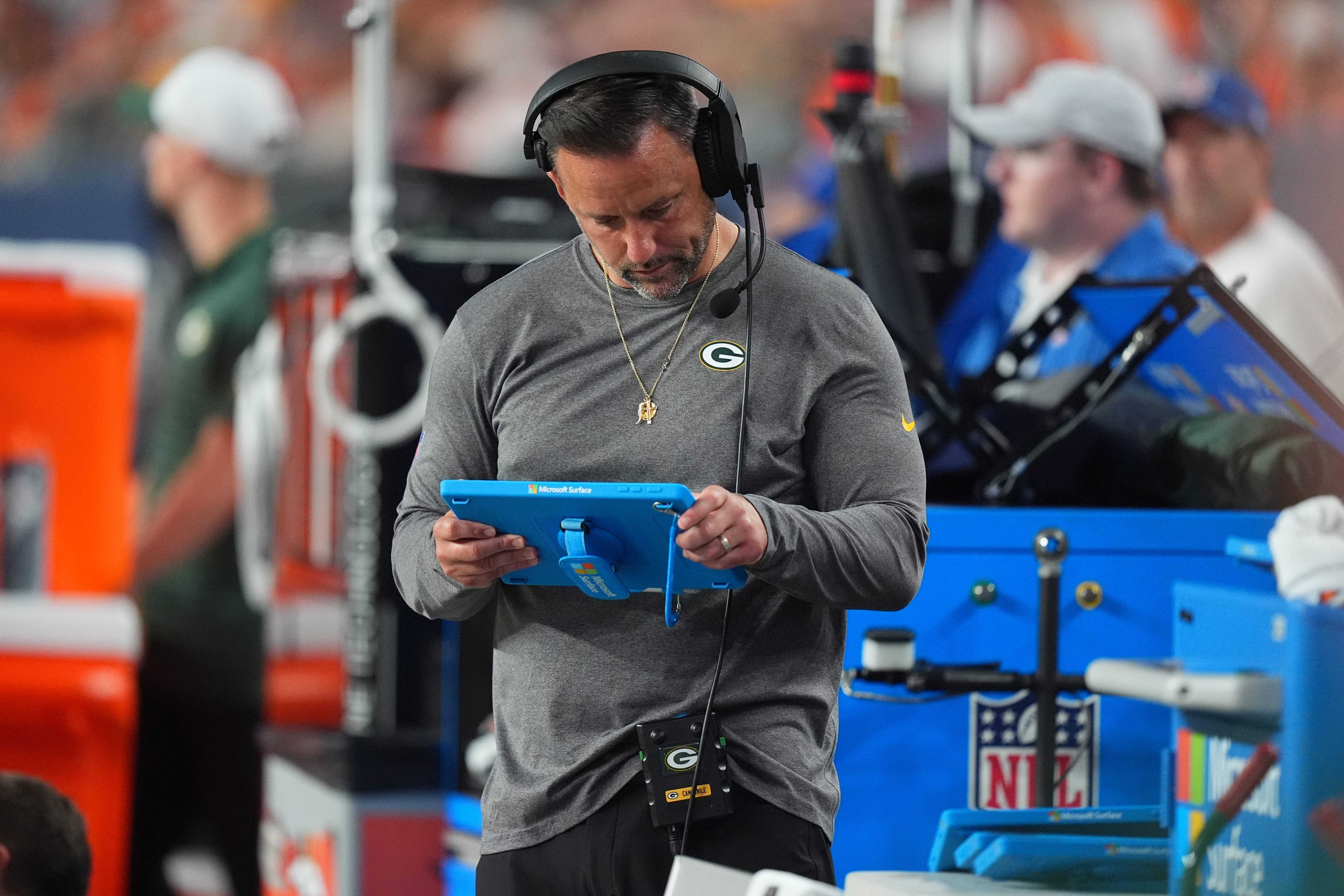 Green Bay Packers linebackers coach Anthony Campanile looks at a tablet in the second half against the Denver Broncos at Empower Field at Mile High.