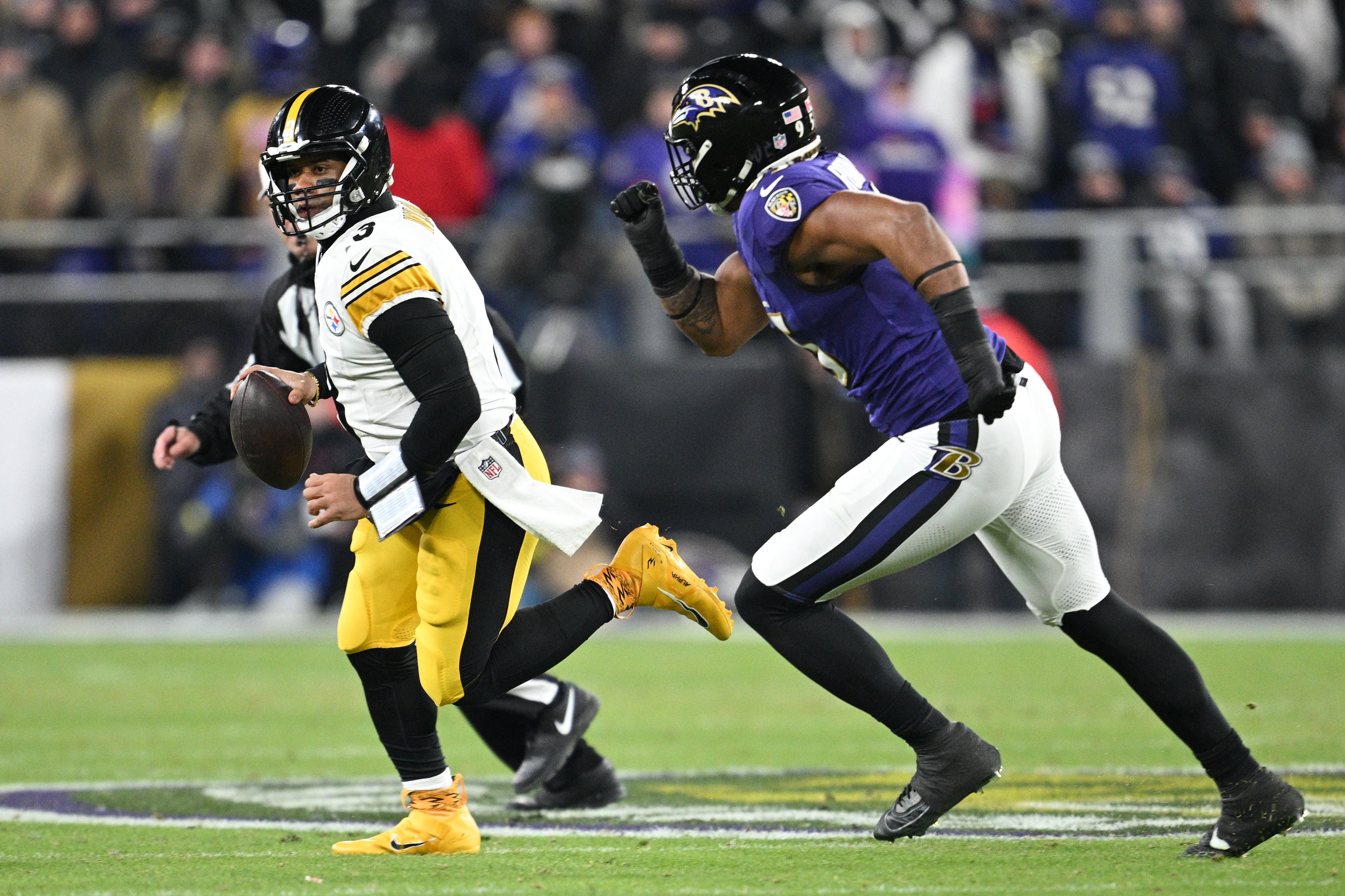 Jan 11, 2025; Baltimore, Maryland, USA; Pittsburgh Steelers quarterback Russell Wilson (3) looks to pass against Baltimore Ravens linebacker Tavius Robinson (95) in the third quarter in an AFC wild card game at M&T Bank Stadium.