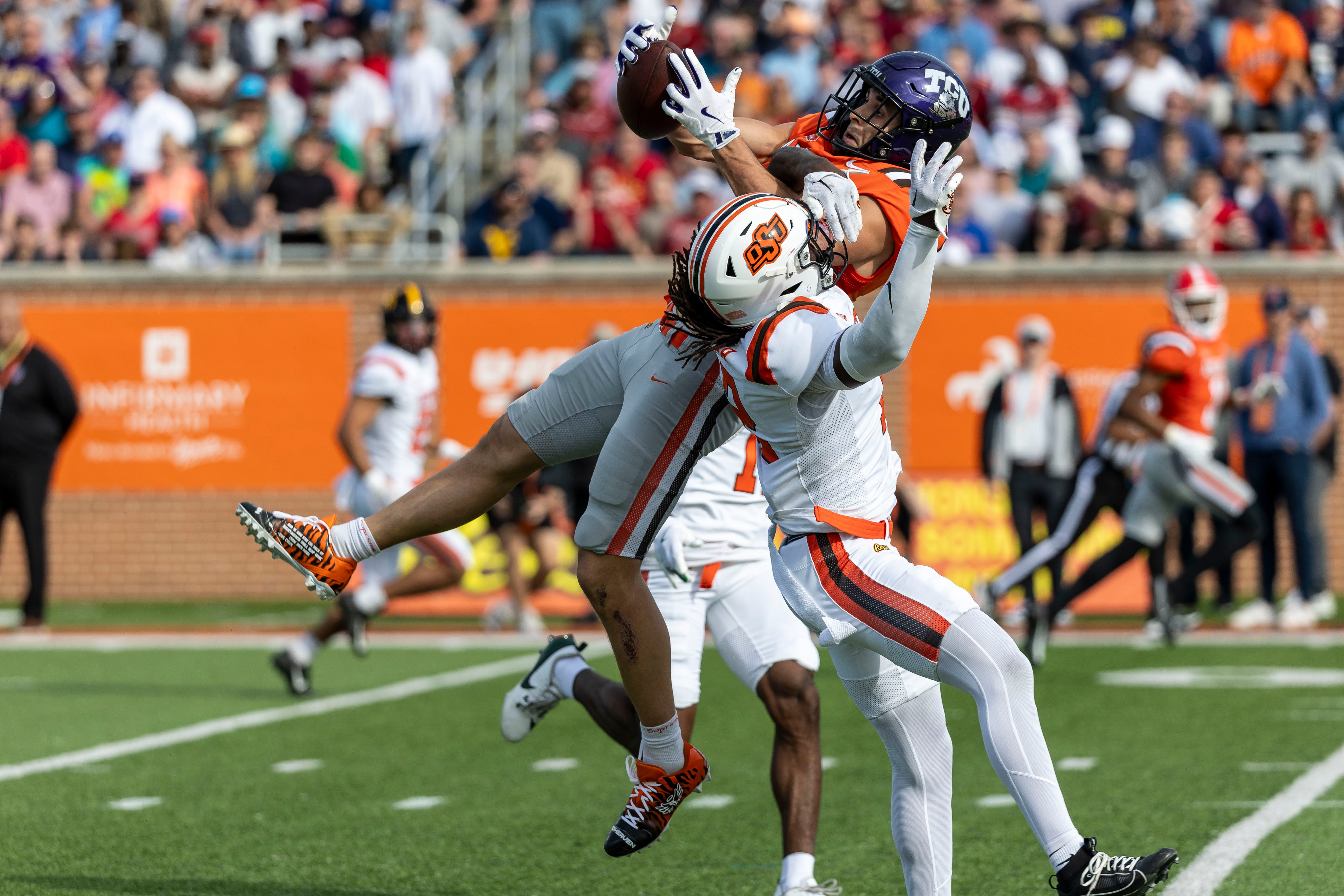 Feb 1, 2025; Mobile, AL, USA; American team wide receiver Jack Bech of TCU (7) grabs a pass over National team safety Trey Rucker of Oklahoma State (22) during the first half at Hancock Whitney Stadium.
