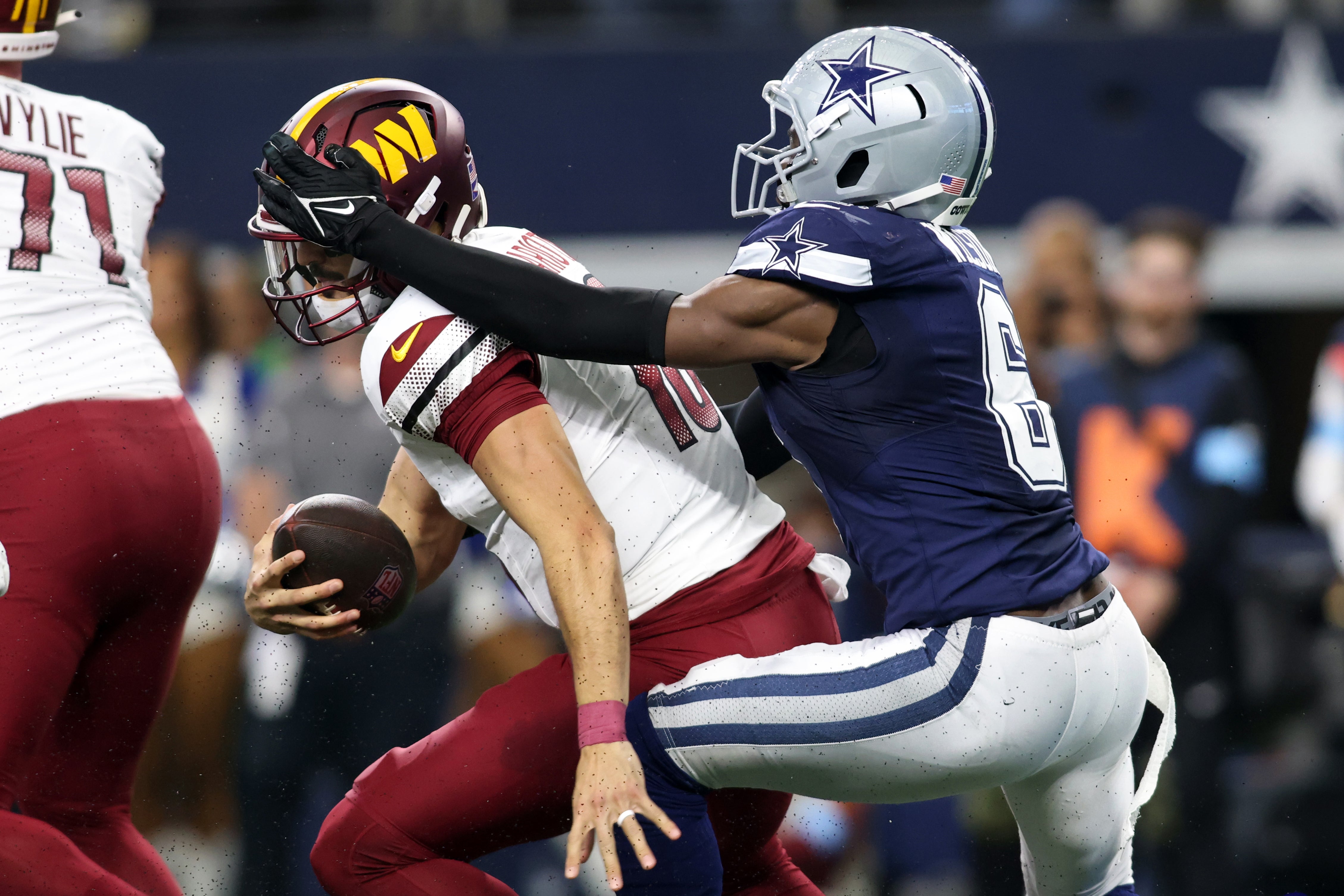 Jan 5, 2025; Arlington, Texas, USA; Dallas Cowboys safety Donovan Wilson (6) tackles Washington Commanders quarterback Marcus Mariota (18) during the second half at AT&T Stadium.