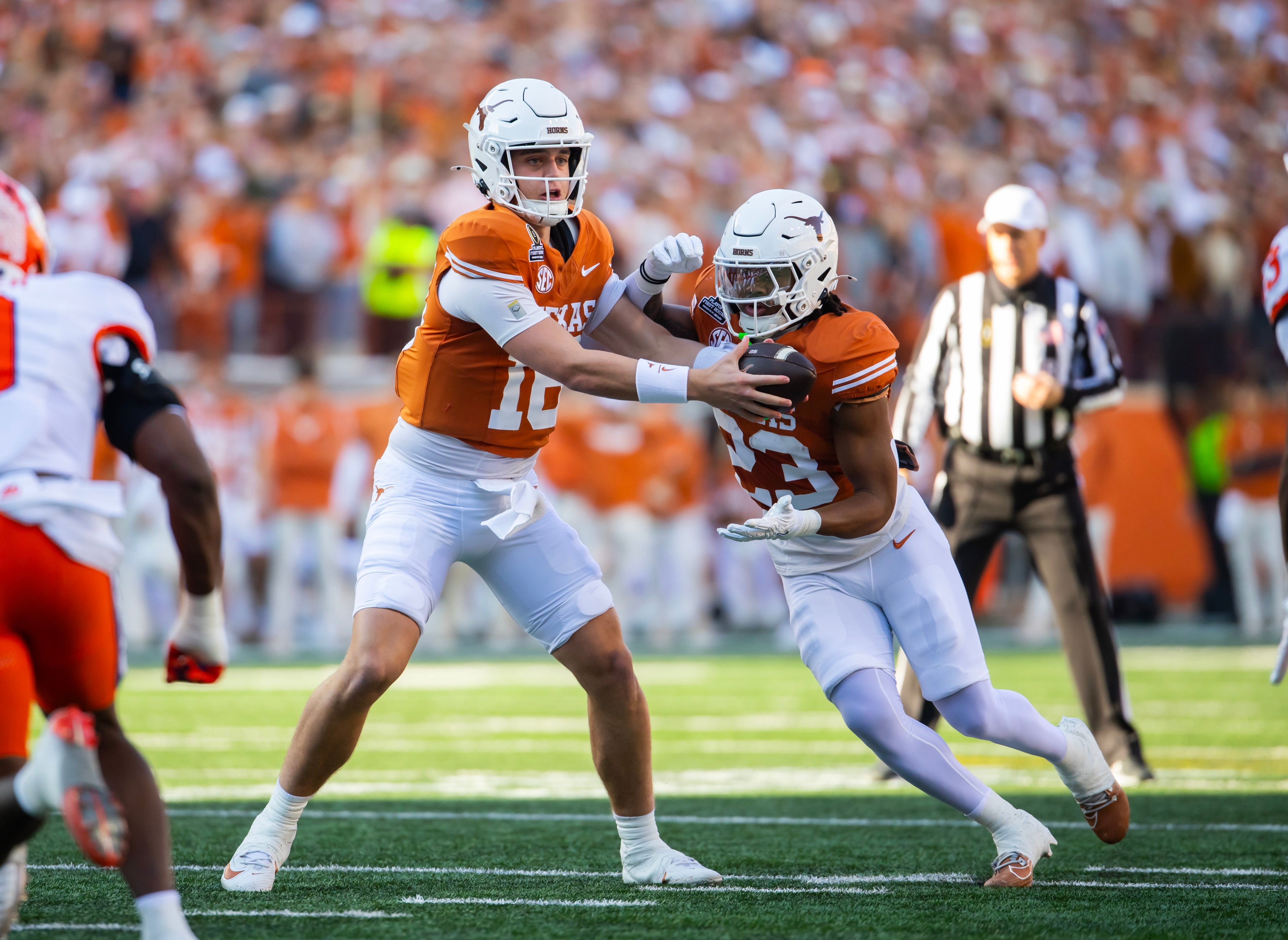 Texas Longhorns running back Jaydon Blue (23) takes the handoff from quarterback Arch Manning (16) against the Clemson Tigers during the CFP National playoff first round at Darrell K Royal-Texas Memorial Stadium.