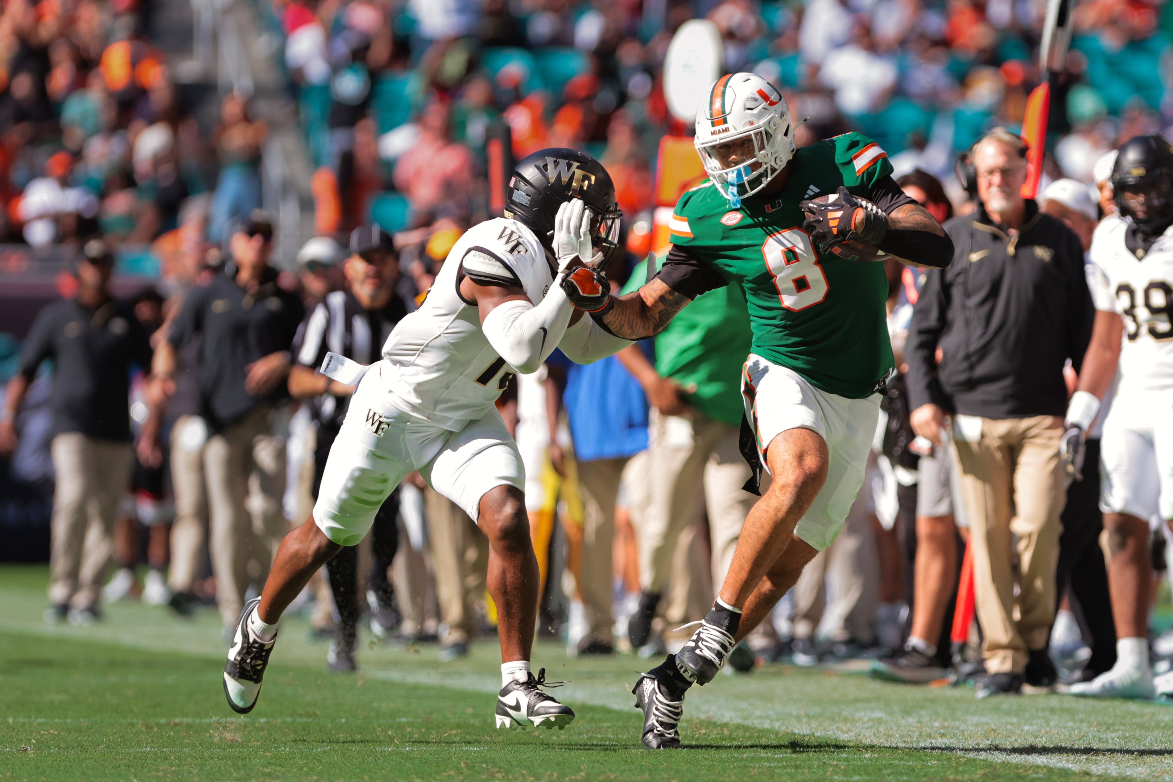 Miami Hurricanes tight end Elijah Arroyo (8) runs with the football against Wake Forest Demon Deacons defensive back Davaughn Patterson (13) during the second quarter at Hard Rock Stadium.