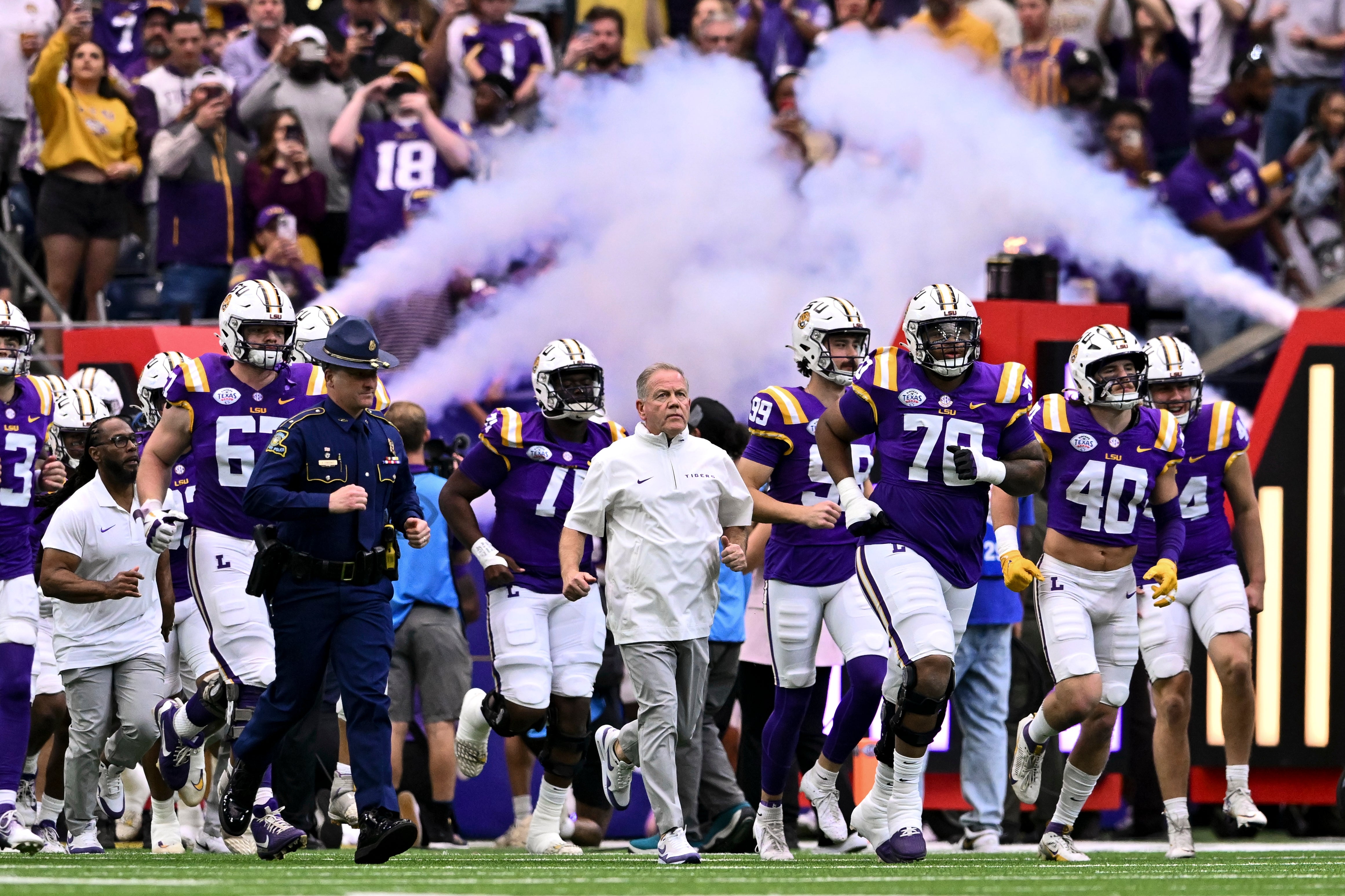 Brian Kelly runs out onto the field with his LSU Tigers