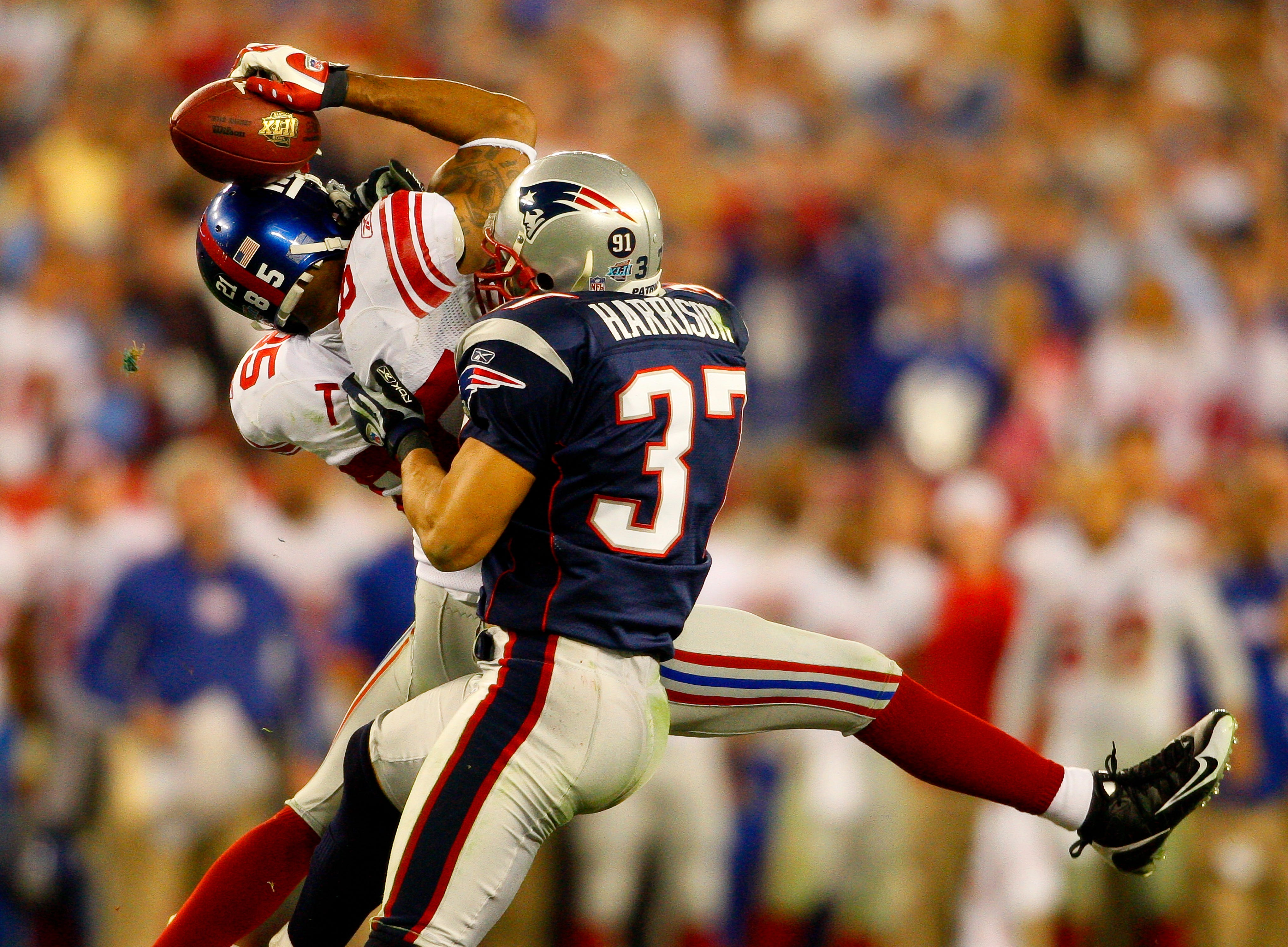 New York Giants receiver David Tyree catches a pass while in the clutches of New England Patriots safety Rodney Harrison during the fourth quarter of the Super Bowl XLII football game in Glendale, Ariz. on Feb. 3, 2008.