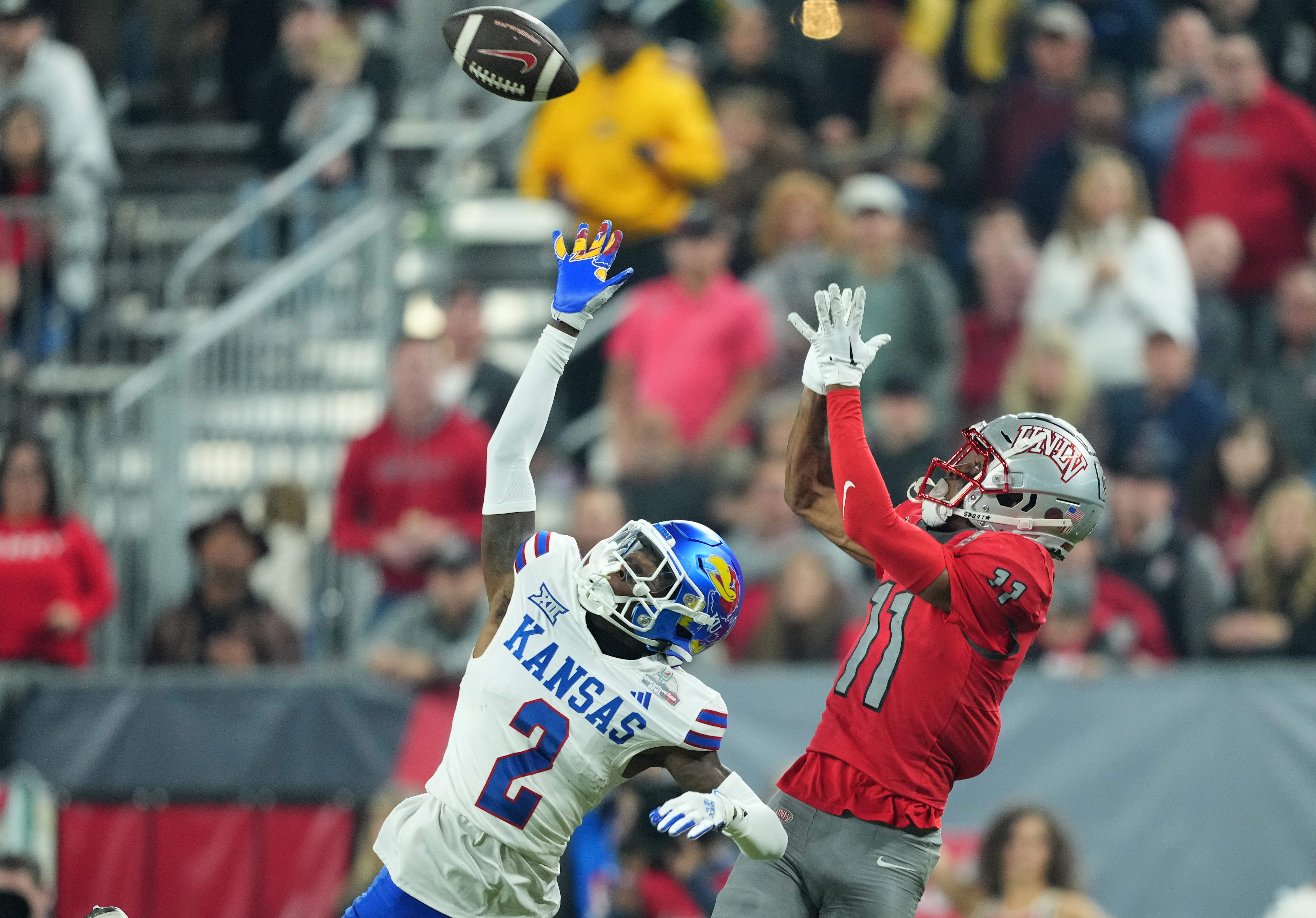 Dec 26, 2023; Phoenix, AZ, USA; UNLV Rebels wide receiver Ricky White (11) catches a touchdown pass against Kansas Jayhawks cornerback Cobee Bryant (2) during the second half at Chase Field.