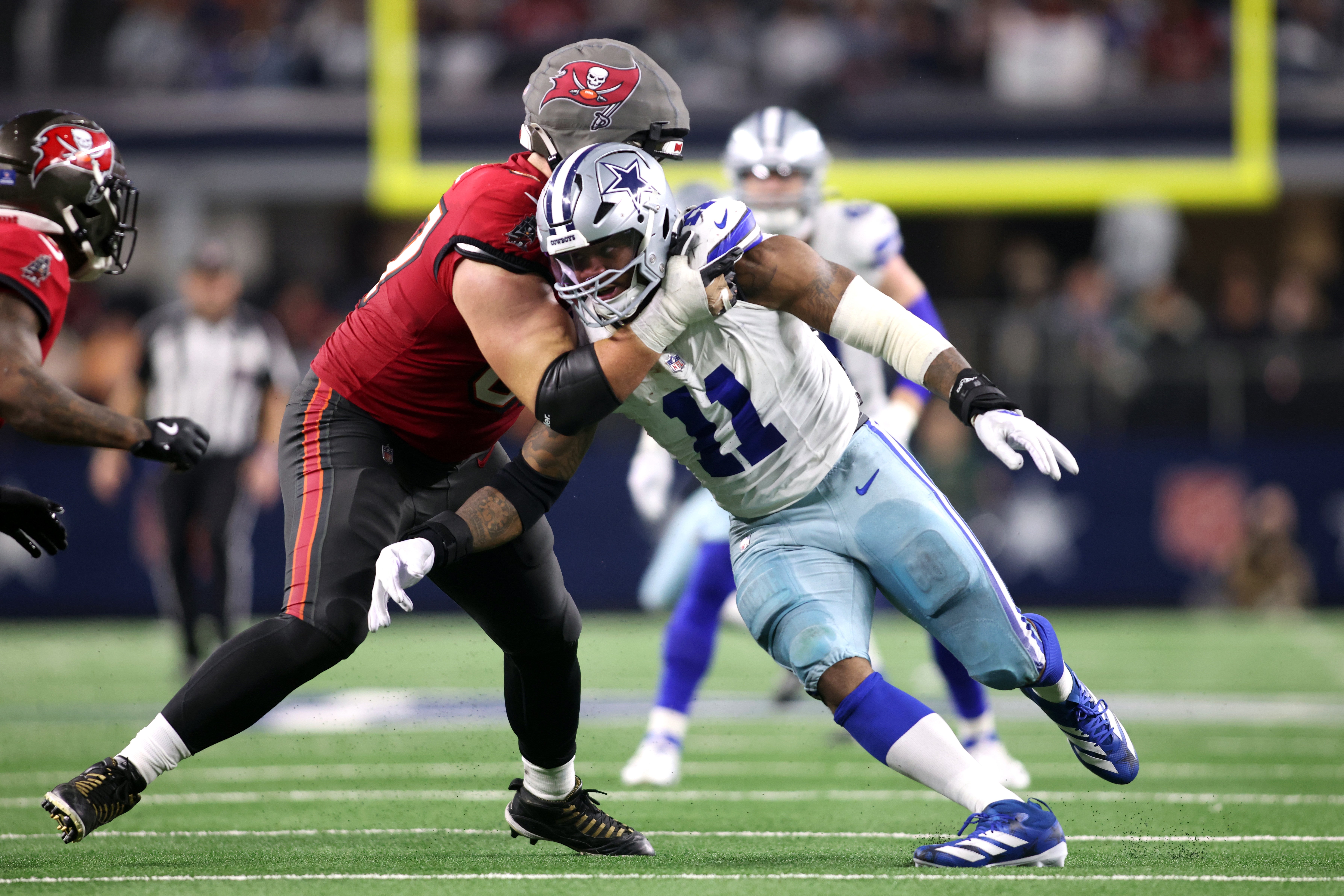 Dallas Cowboys linebacker Micah Parsons (11) rushes the passer against Tampa Bay Buccaneers offensive tackle Luke Goedeke (67) in the fourth quarter at AT&T Stadium.