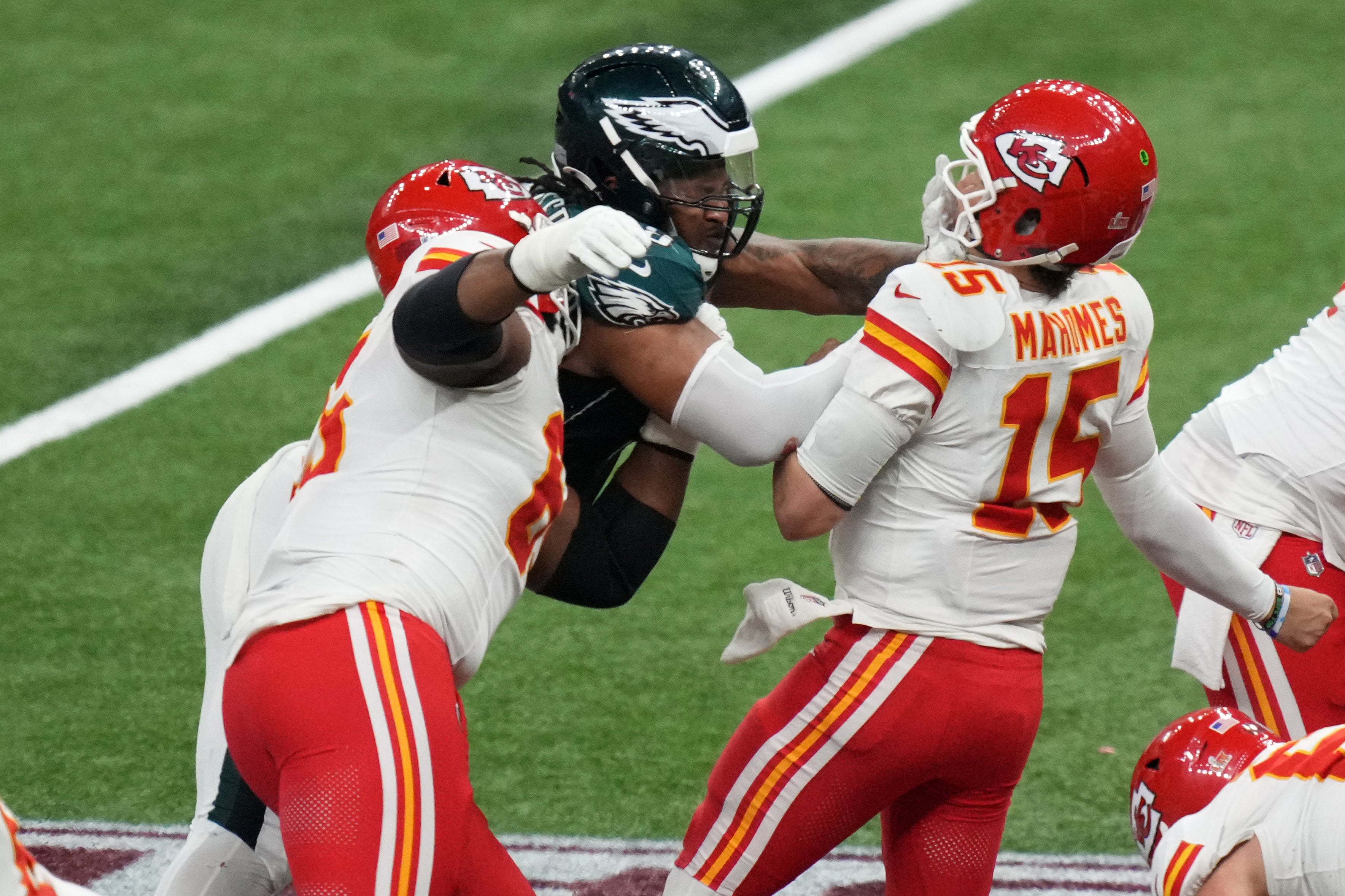 Feb 9, 2025; New Orleans, LA, USA; Kansas City Chiefs quarterback Patrick Mahomes (15) is sacked by Philadelphia Eagles defensive tackle Jalen Carter (98) and defensive tackle Milton Williams (93) during the fourth quarter in Super Bowl LIX at Caesars Superdome.