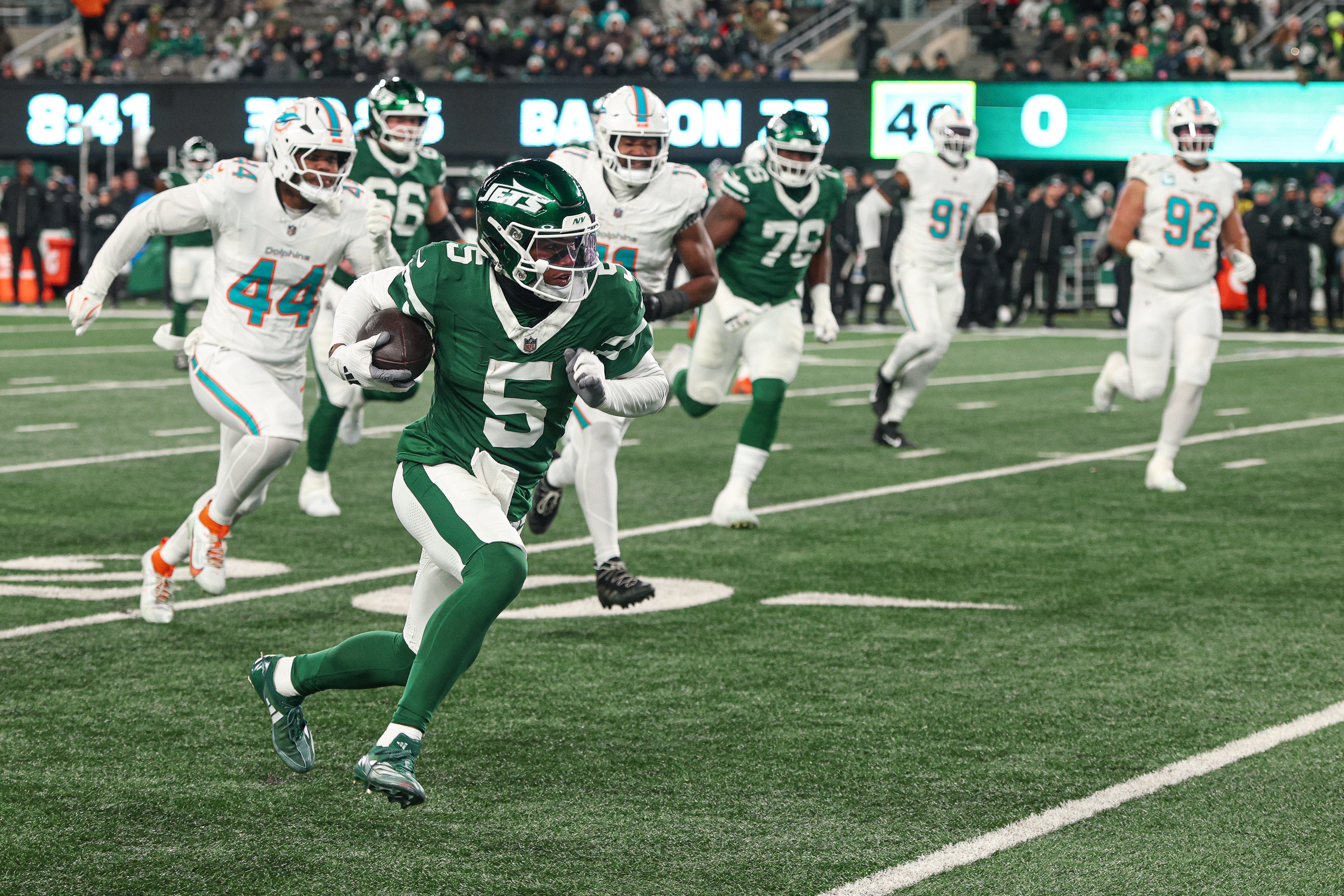 New York Jets wide receiver Garrett Wilson (5) gains yards after catch as Miami Dolphins linebacker Chop Robinson (44) pursues during the first half at MetLife Stadium.