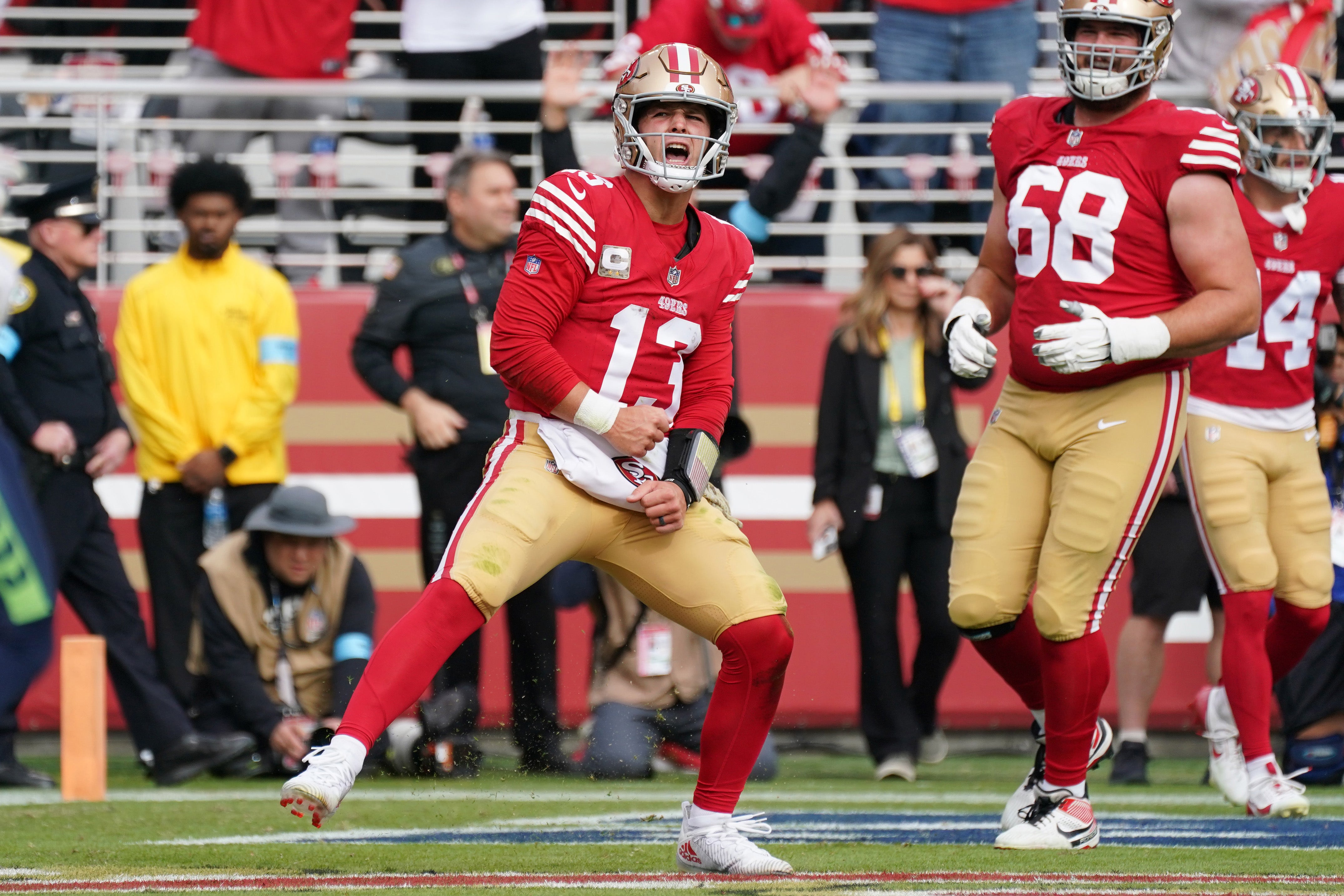 San Francisco 49ers quarterback Brock Purdy (13) celebrates after scoring a touchdown against the Seattle Seahawks in first quarter as San Francisco 49ers offensive tackle Colton McKivitz (68) looks on at Levi's Stadium.