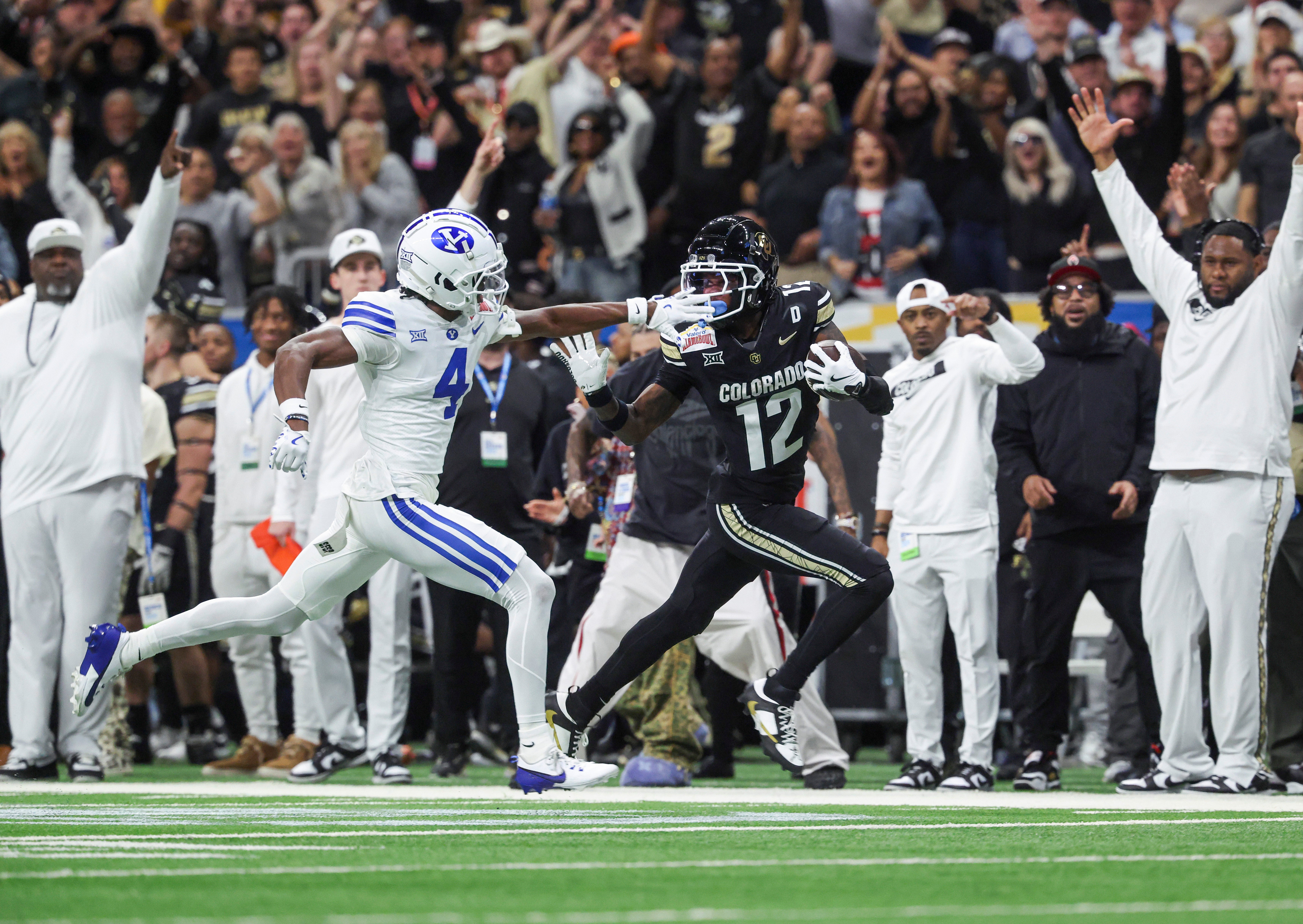 Colorado Buffaloes wide receiver Travis Hunter (12) runs with the ball as Brigham Young Cougars cornerback Mory Bamba (4) attempts to make a tackle during the second quarter at Alamodome. 
