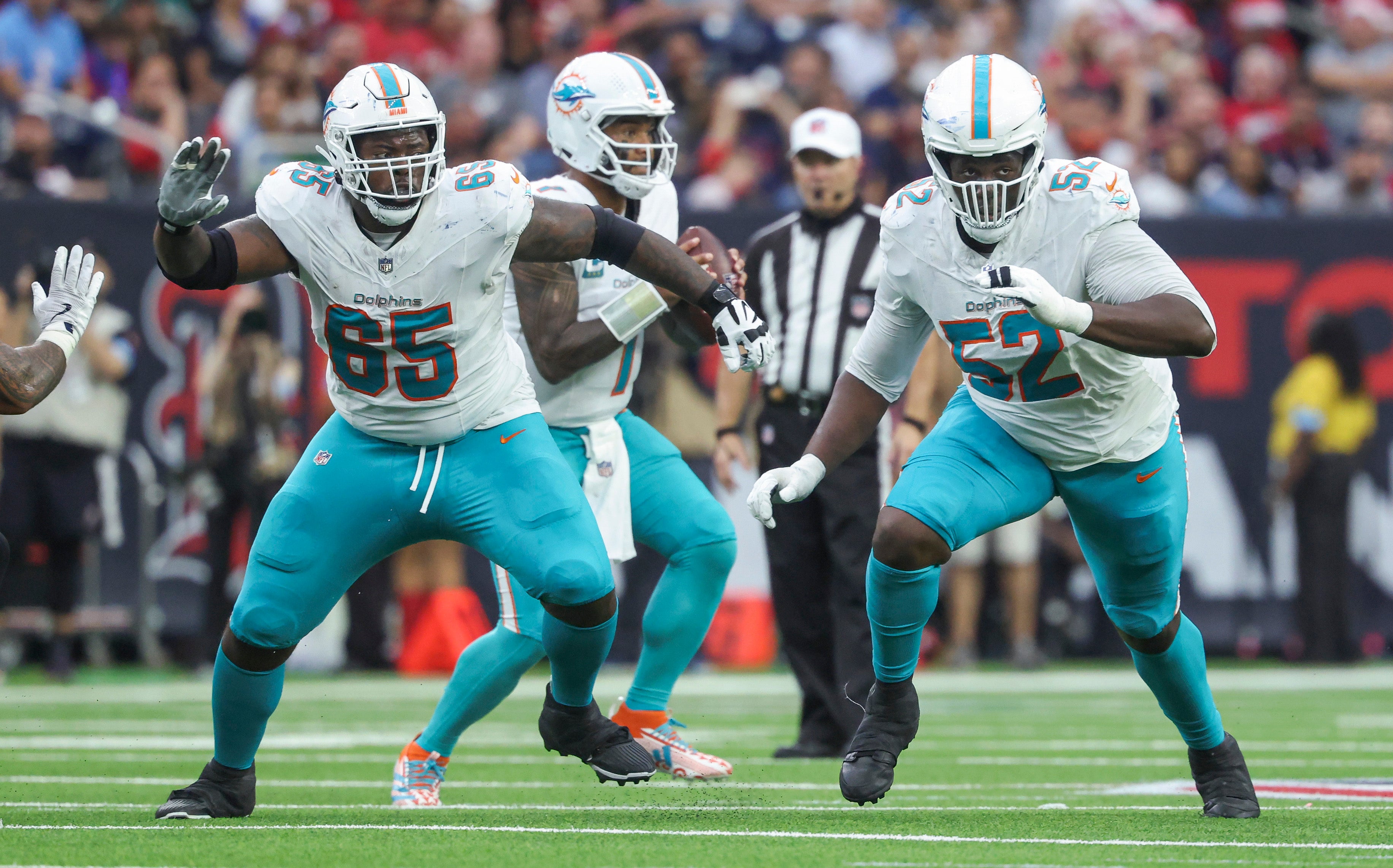 Dec 15, 2024; Houston, Texas, USA; Miami Dolphins guard Robert Jones (65) and offensive tackle Patrick Paul (52) in pass protection for quarterback Tua Tagovailoa (1) during the game against the Houston Texans at NRG Stadium.
