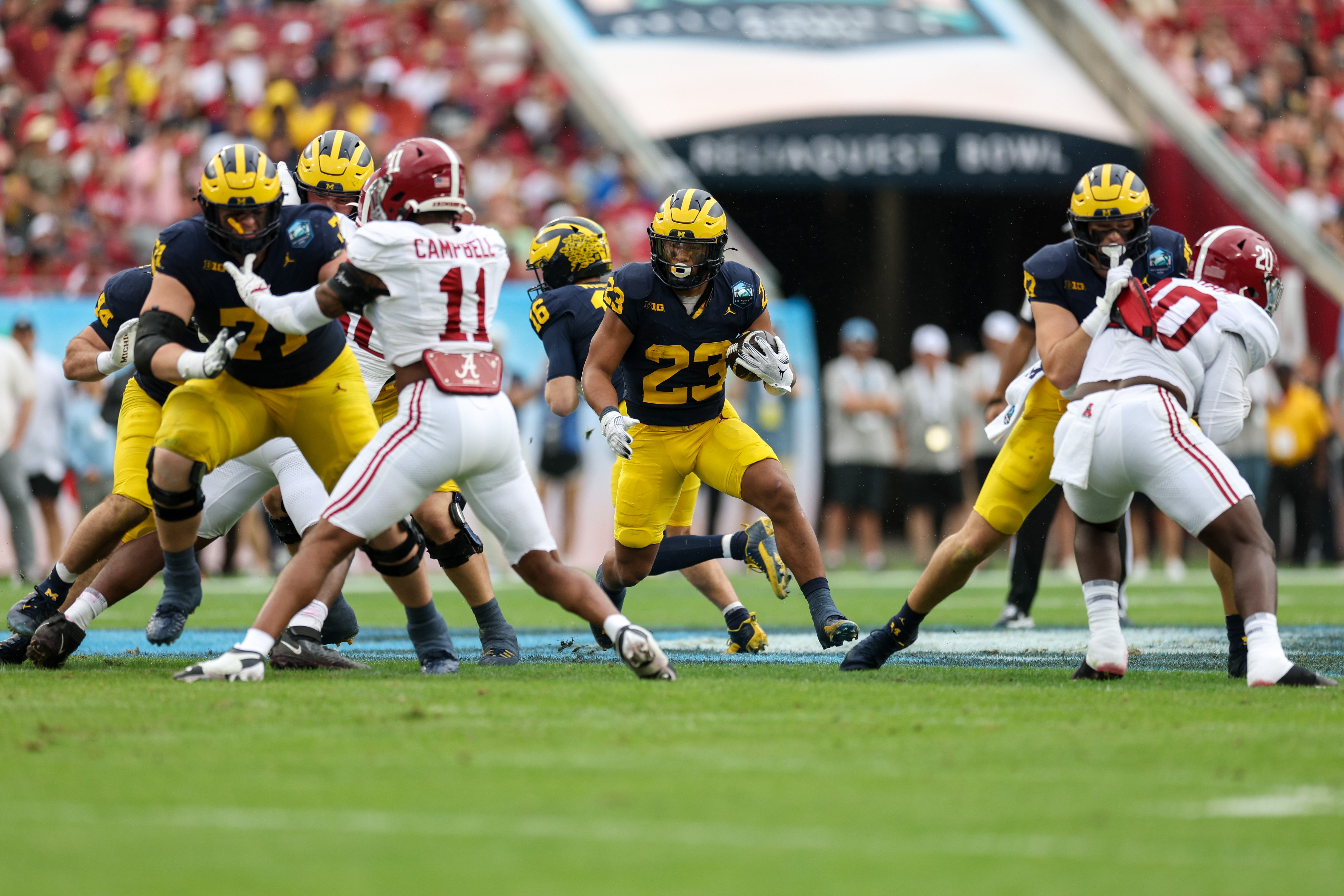 Dec 31, 2024; Tampa, FL, USA; Michigan Wolverines running back Jordan Marshall (23) runs with the ball against the Alabama Crimson Tide in the first quarter during the ReliaQuest Bowl at Raymond James Stadium.