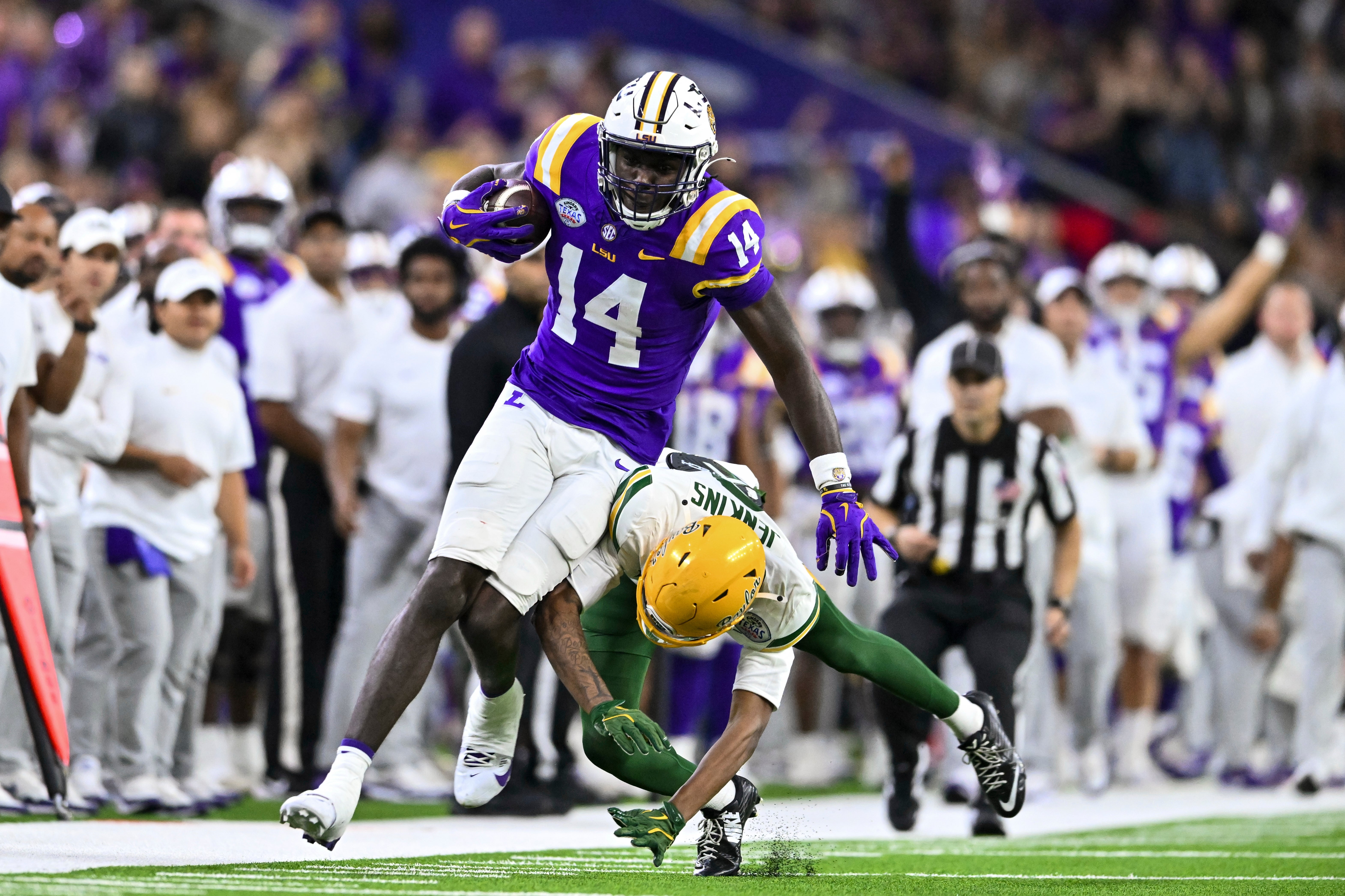 Trey'Dez Green fights through contact after a reception for the LSU Tigers