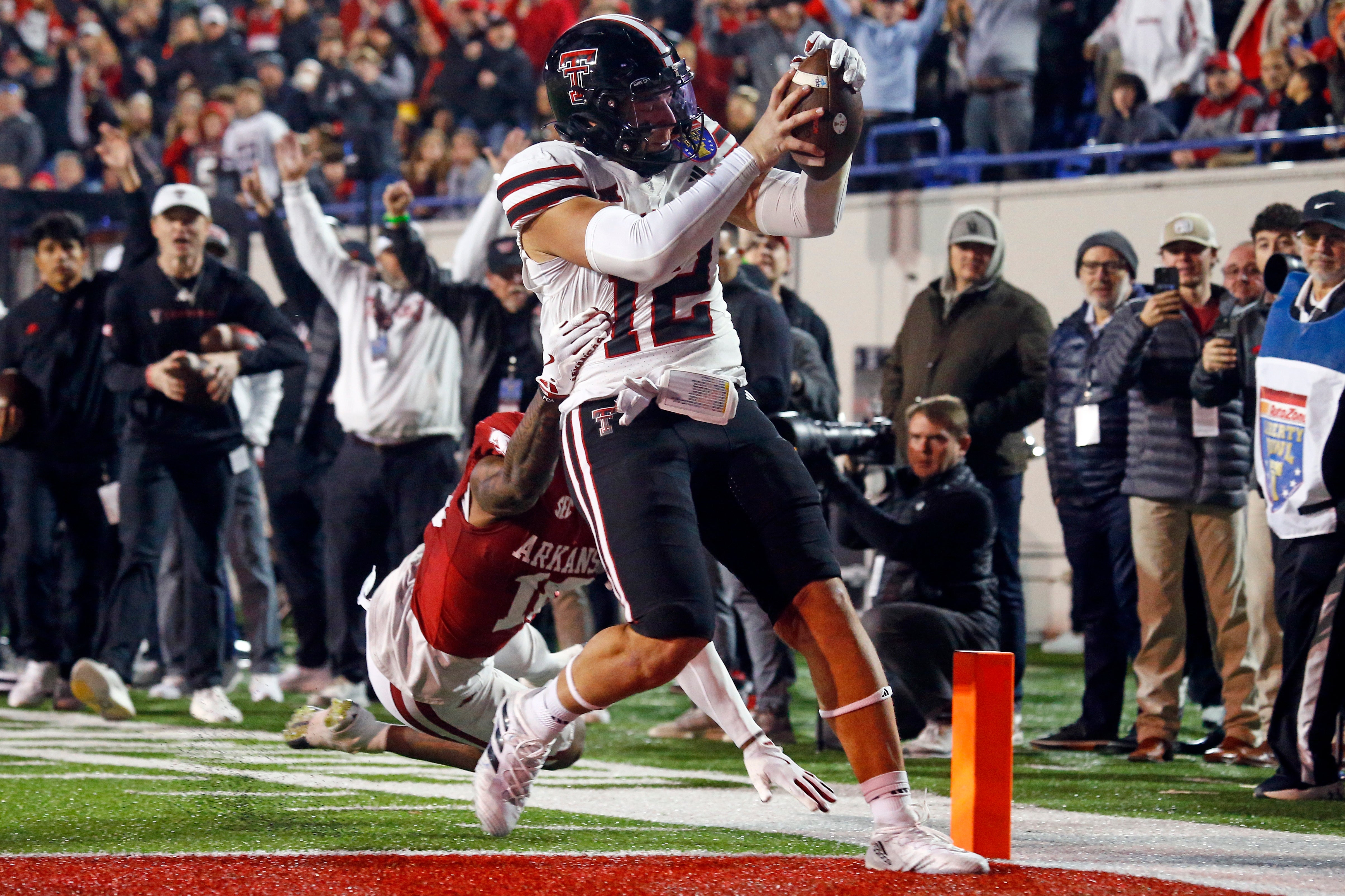 Dec 27, 2024; Memphis, TN, USA; Texas Tech Red Raiders tight end Jalin Conyers (12) runs the ball for a touchdown as Arkansas Razorbacks linebacker Xavian Sorey Jr. (10) attempts to make the tackle during the second quarter at Simmons Bank Liberty Stadium.