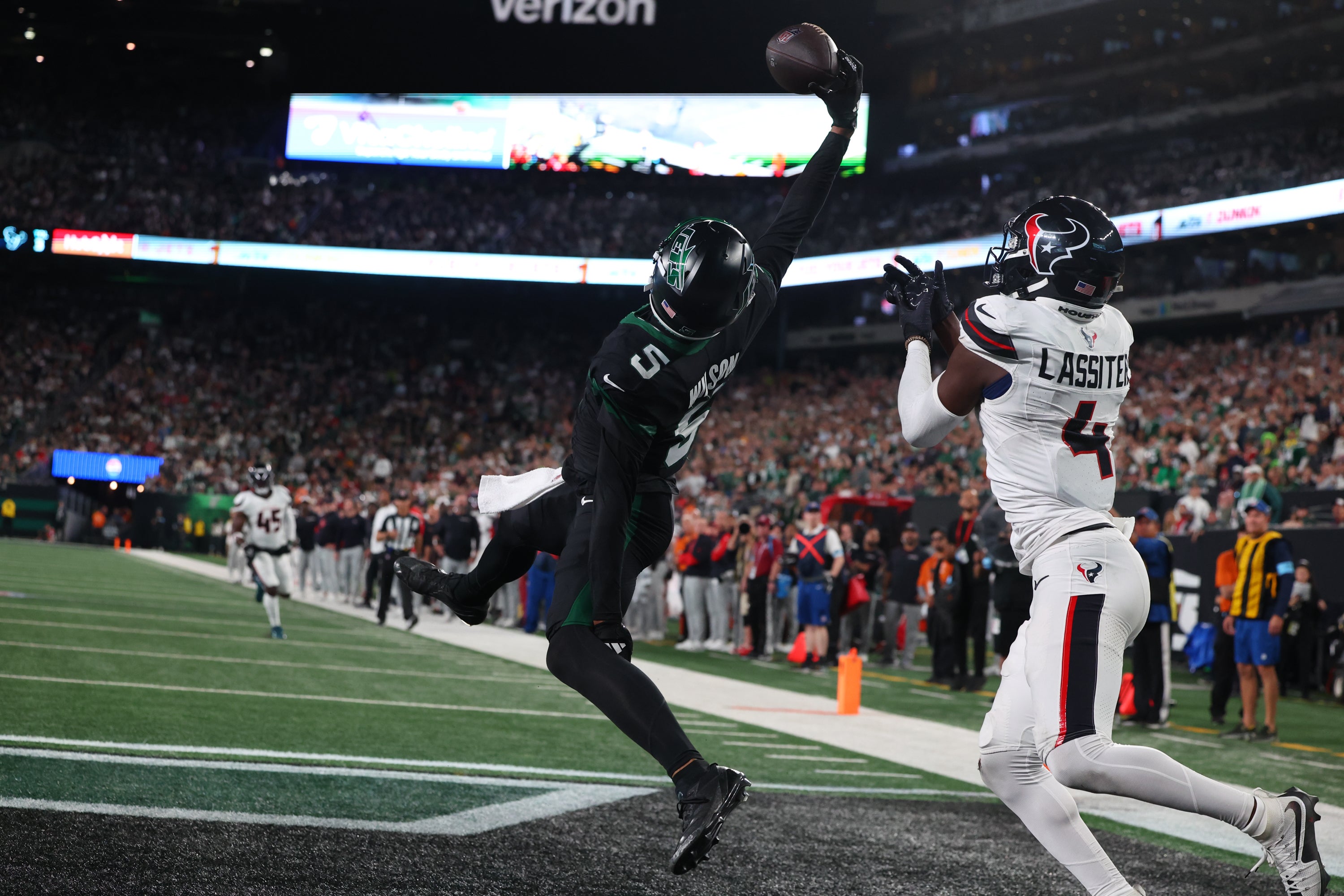 New York Jets wide receiver Garrett Wilson (5) catches a touchdown pass while being defended by Houston Texans cornerback Kamari Lassiter (4) during the second half at MetLife Stadium.
