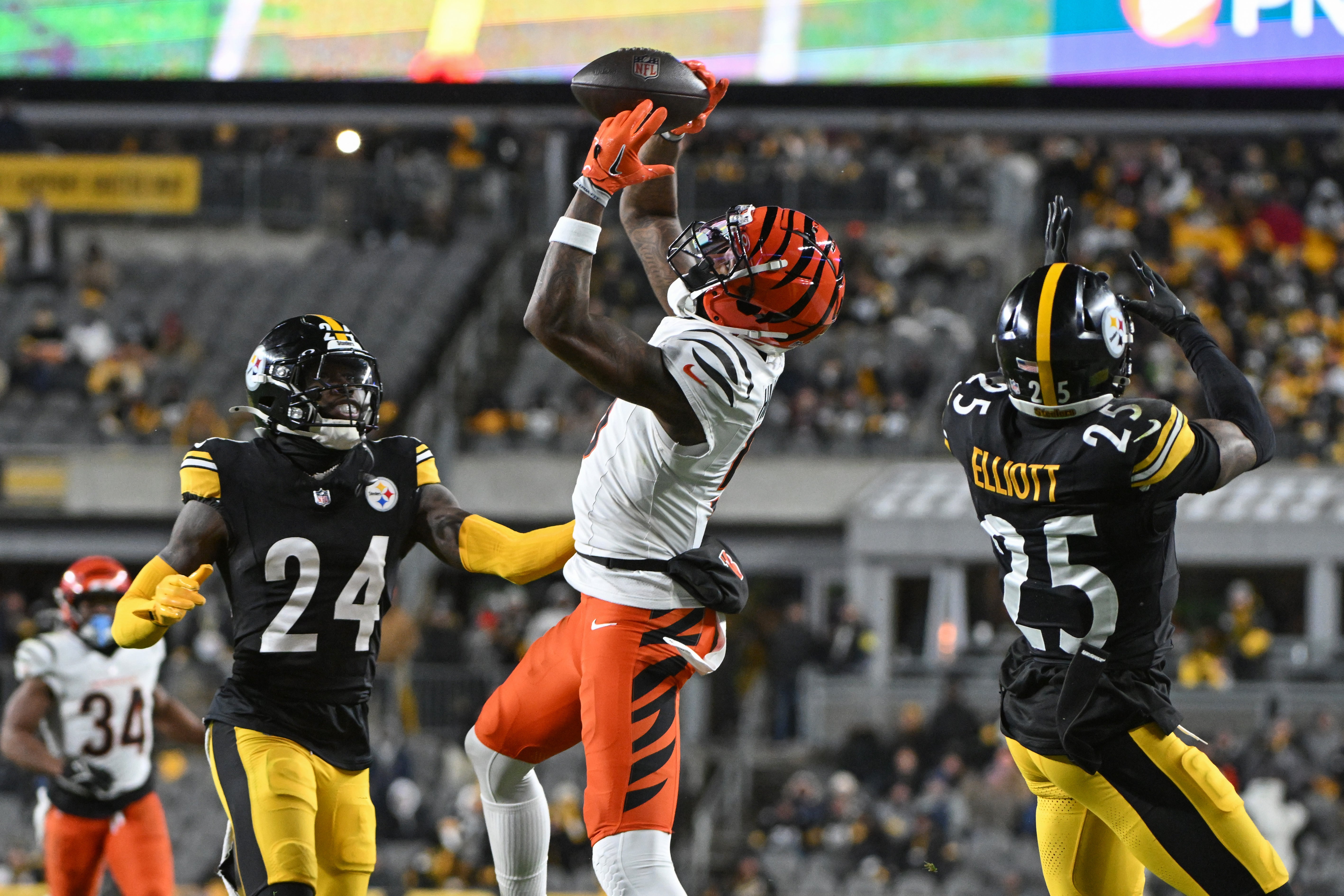 Jan 4, 2025; Pittsburgh, Pennsylvania, USA; Cincinnati Bengals wide receiver Tee Higgins (5) catches a pass in front of Pittsburgh Steelers cornerback Joey Porter Jr. (24) and safety DeShon Elliott (25) during the second quarter at Acrisure Stadium.
