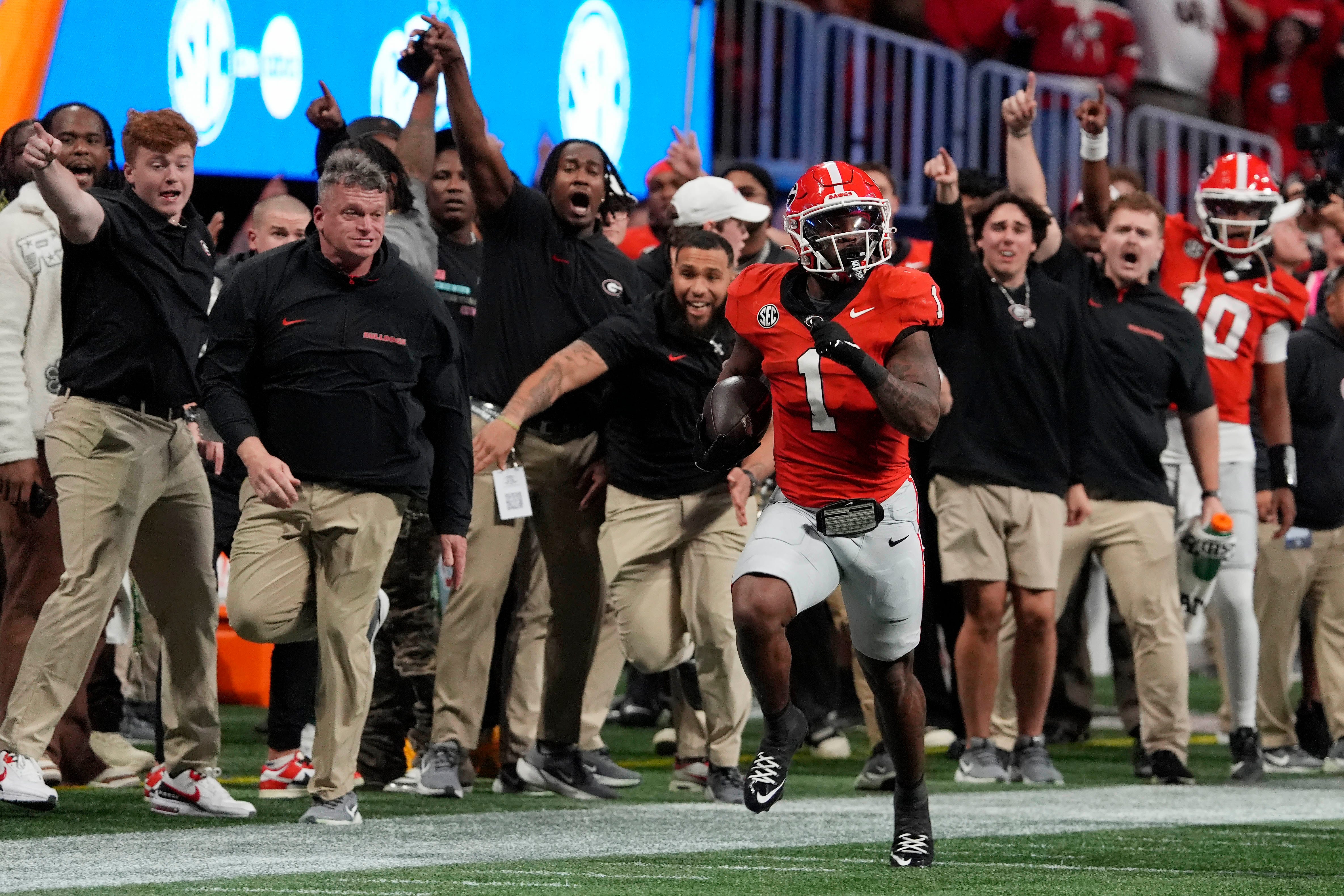 The Georgia sideline goes wild while Georgia running back Trevor Etienne (1) breaks away for a big gain during the second half of the SEC championship game against Texas in Atlanta, on Saturday, Dec. 7, 2024.