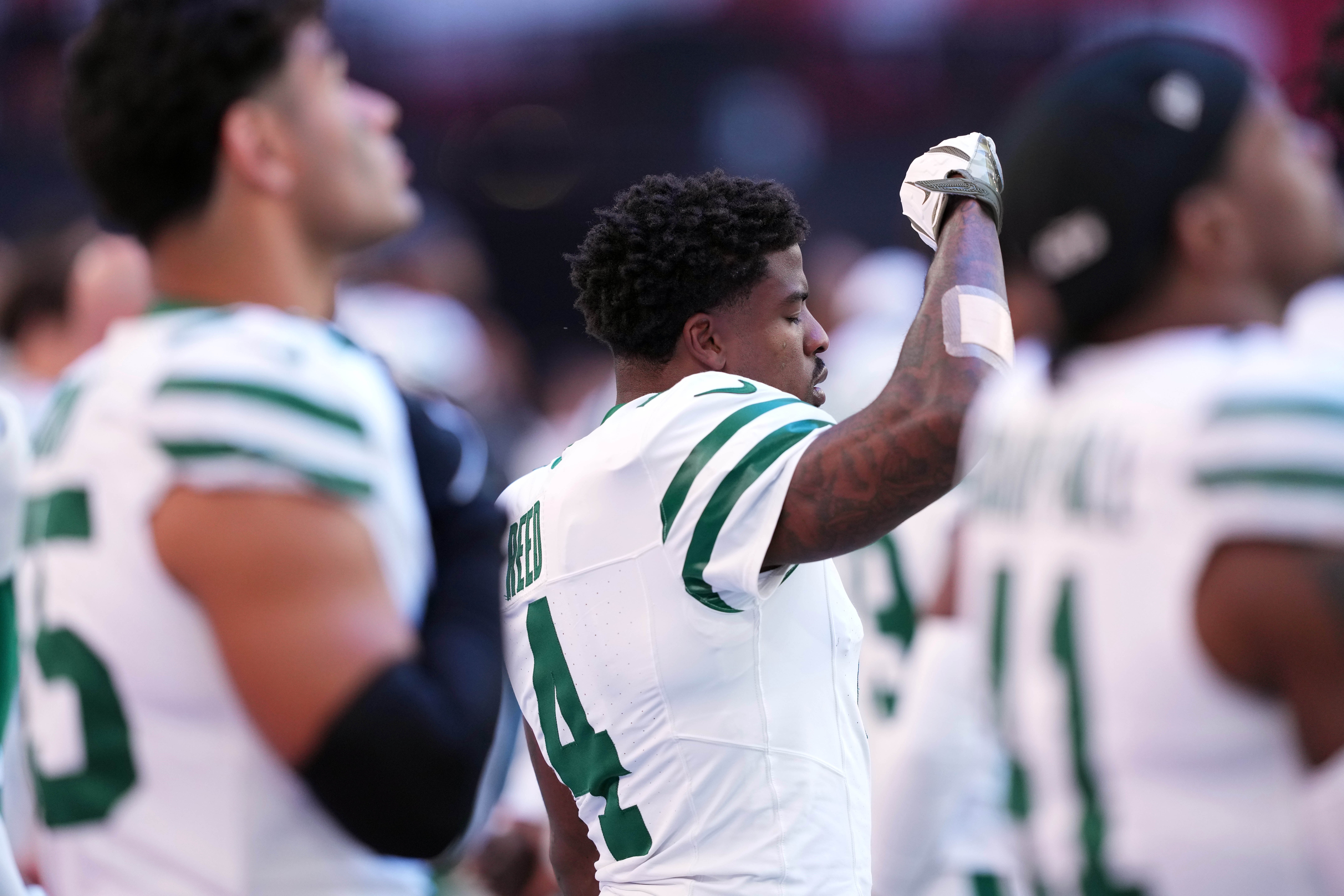Nov 10, 2024; Glendale, Arizona, USA; New York Jets cornerback D.J. Reed (4) raises his fist during the national anthem before the game against the Arizona Cardinals at State Farm Stadium.