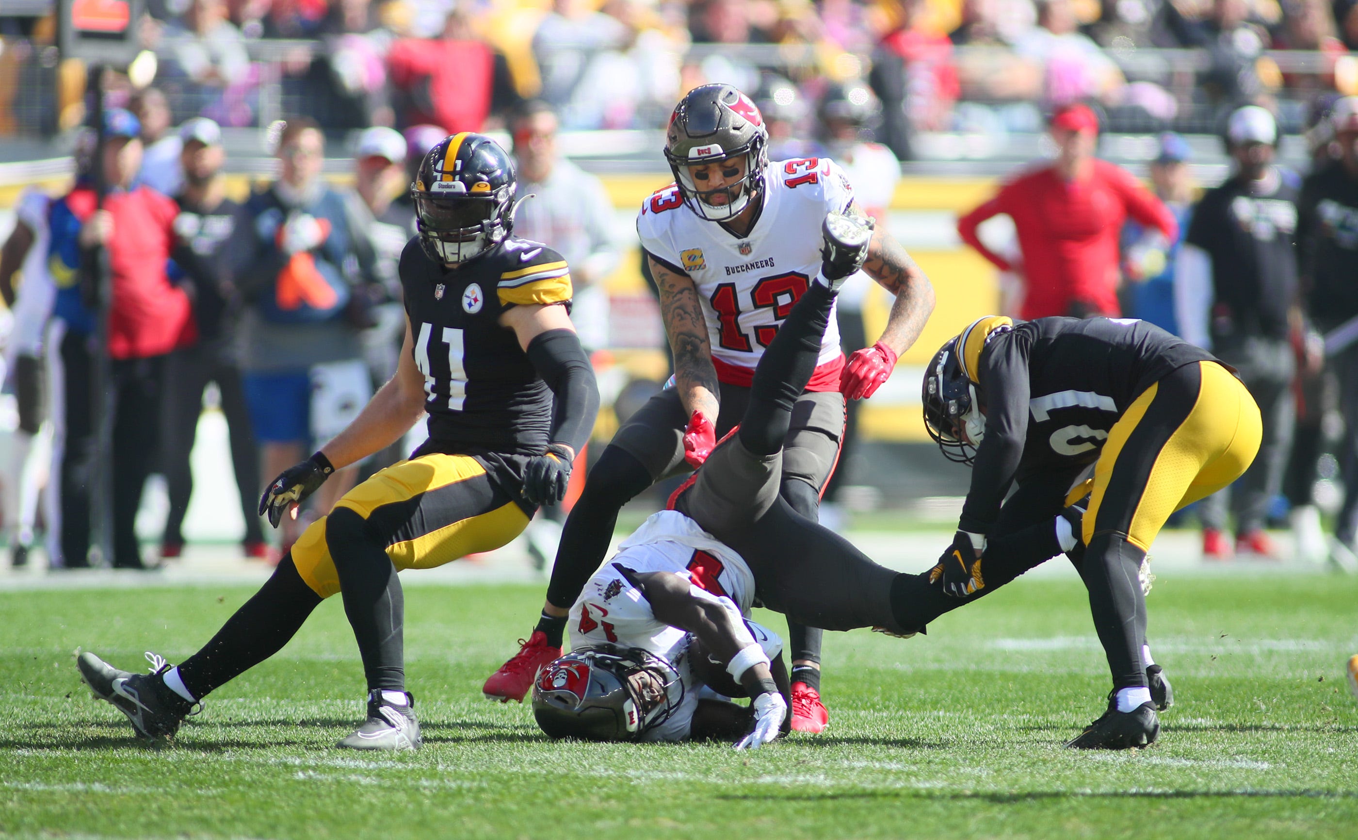 Chris Godwin (14) of the Tampa Bay Buccaneers gets tackled by Tre Norwood (21) of the Pittsburgh Steelers during the first half at Acrisure Stadium in Pittsburgh, PA on October 16, 2022. Pittsburgh Steelers Vs Tampa Bay Buccaneers Week 6