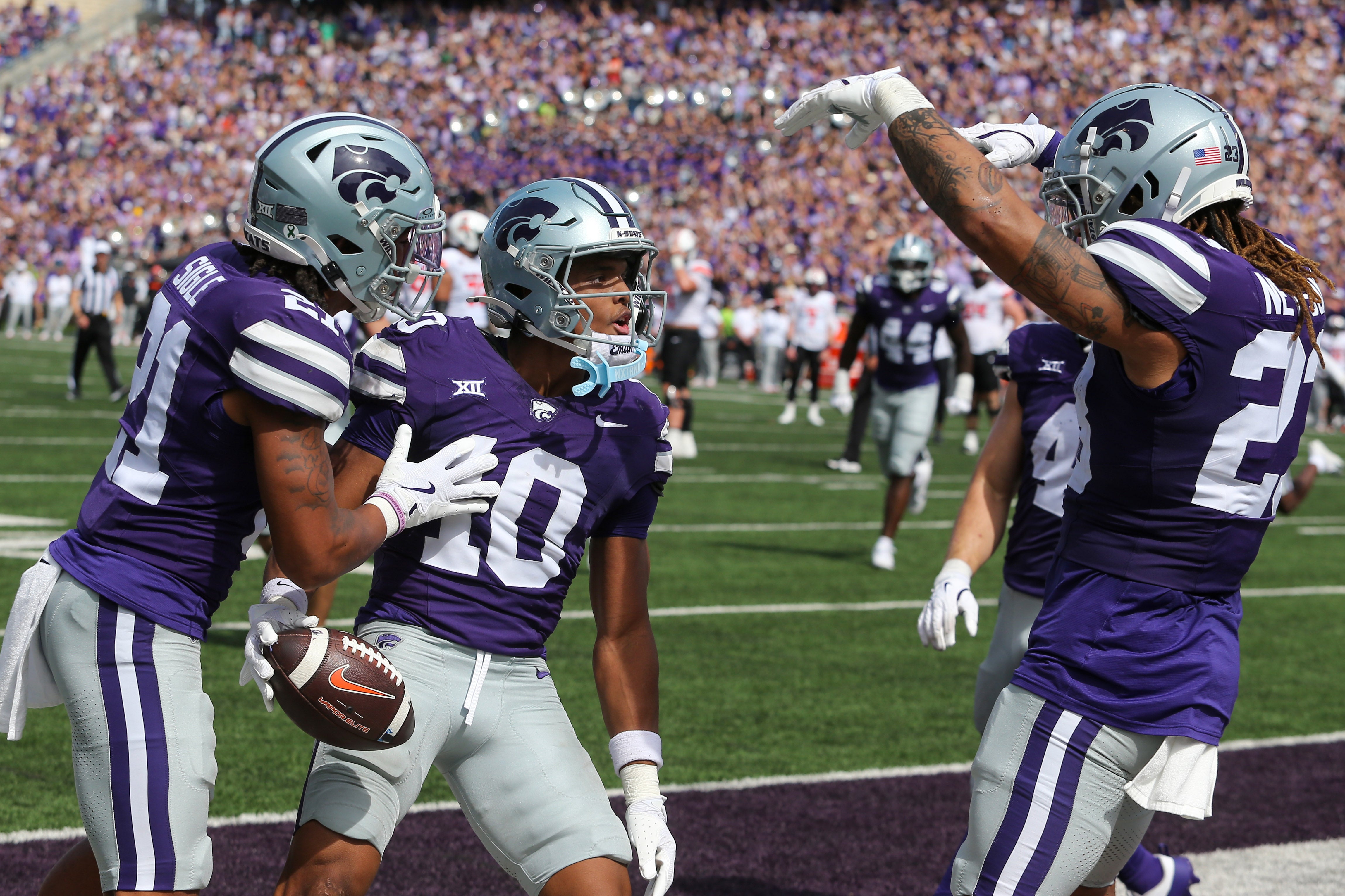 Sep 28, 2024; Manhattan, Kansas, USA; Kansas State Wildcats cornerback Jacob Parrish (10) celebrates with safety Marques Sigle (21) and linebacker Asa Newsom (23) after intercepting a pass against the Oklahoma State Cowboys in the third quarter at Bill Snyder Family Football Stadium.