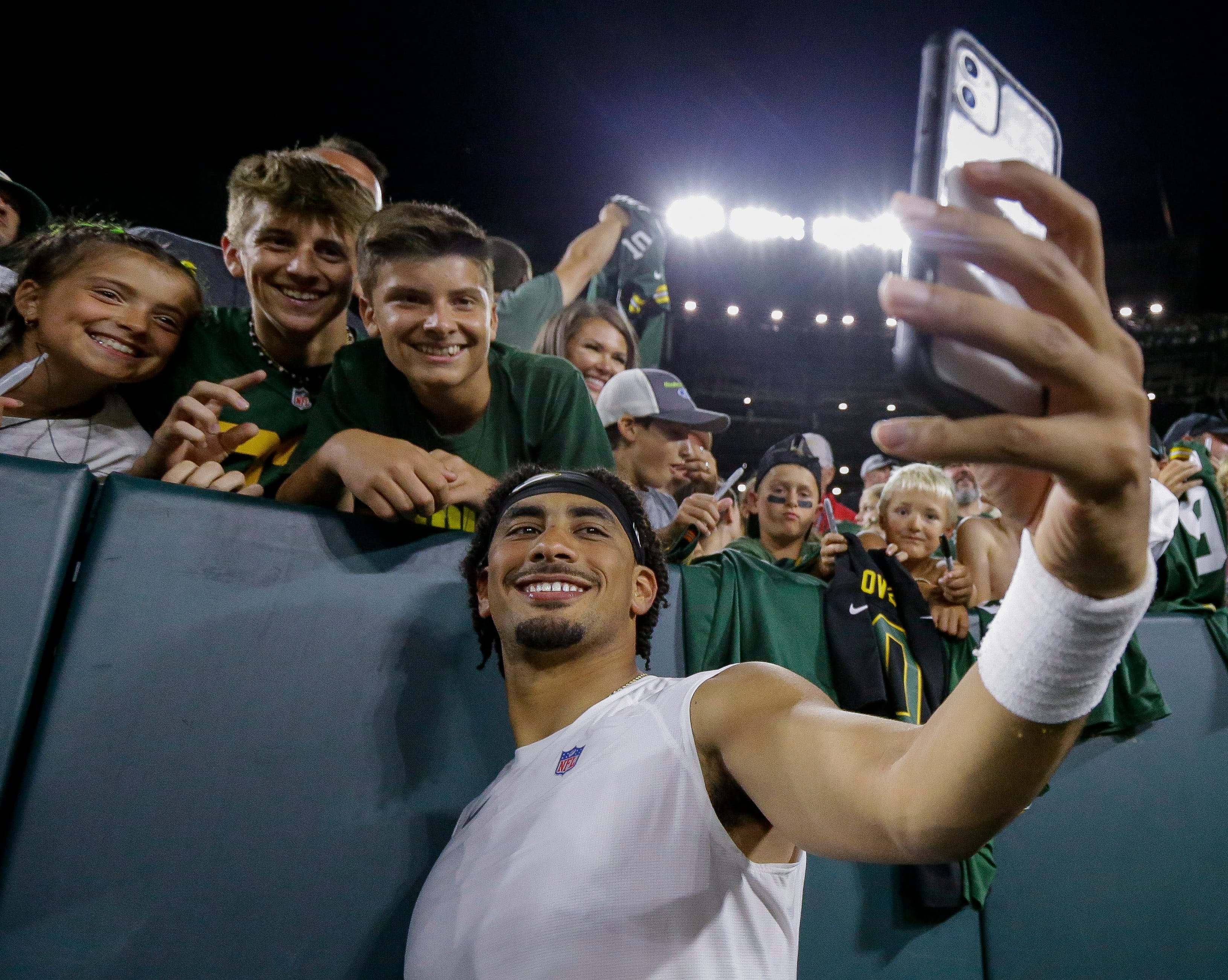 Green Bay Packers quarterback Jordan Love takes a selfie with fans during Family Night on Saturday, August 3, 2024, at Lambeau Field in Green Bay