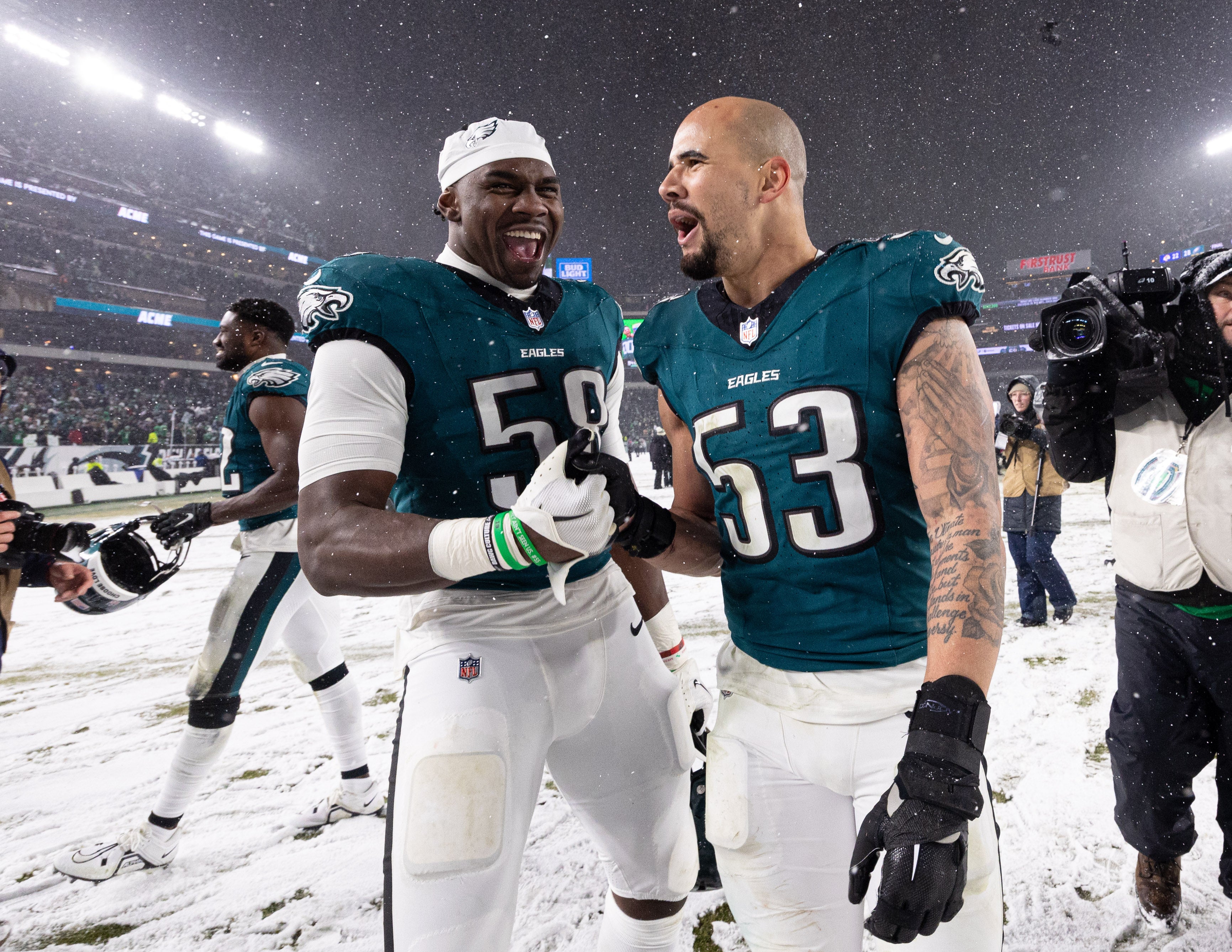 Philadelphia Eagles linebacker Zack Baun (53) and linebacker Jalyx Hunt (58) celebrate a victory against the Los Angeles Rams after a 2025 NFC divisional round game at Lincoln Financial Field.