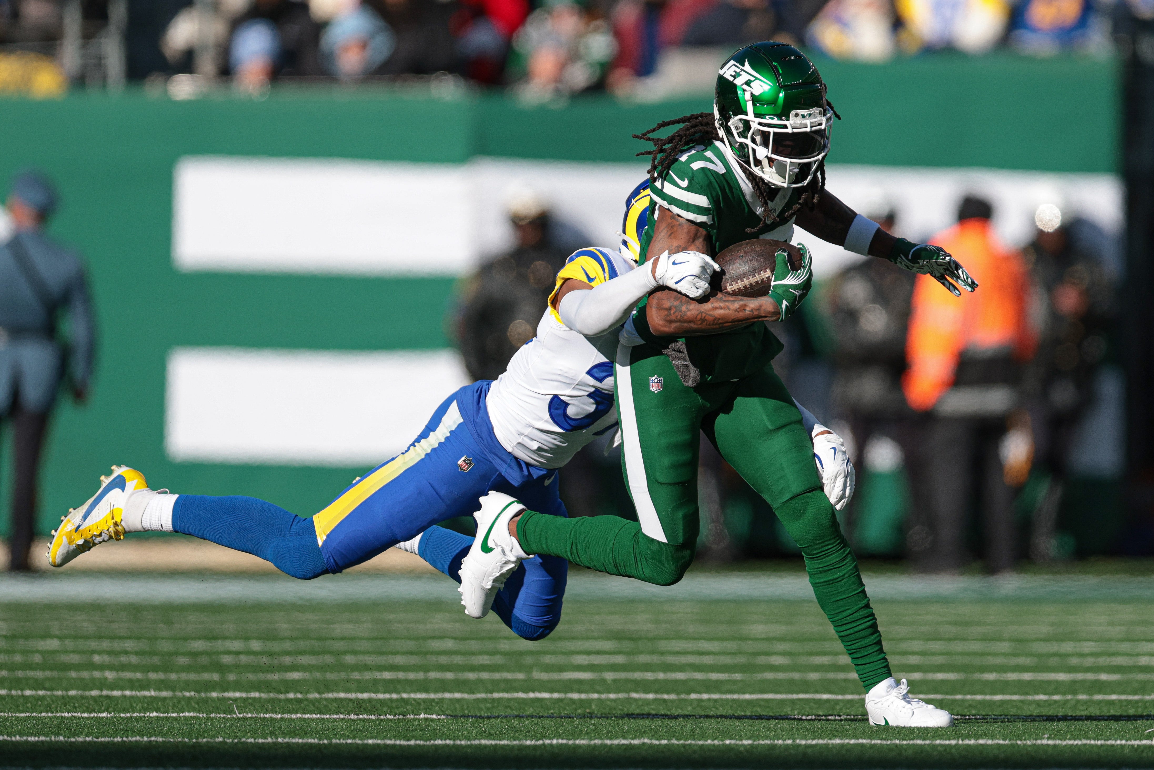 Dec 22, 2024; East Rutherford, New Jersey, USA; New York Jets wide receiver Davante Adams (17) fights for yards as Los Angeles Rams safety Quentin Lake (37) tackles during the first half at MetLife Stadium.