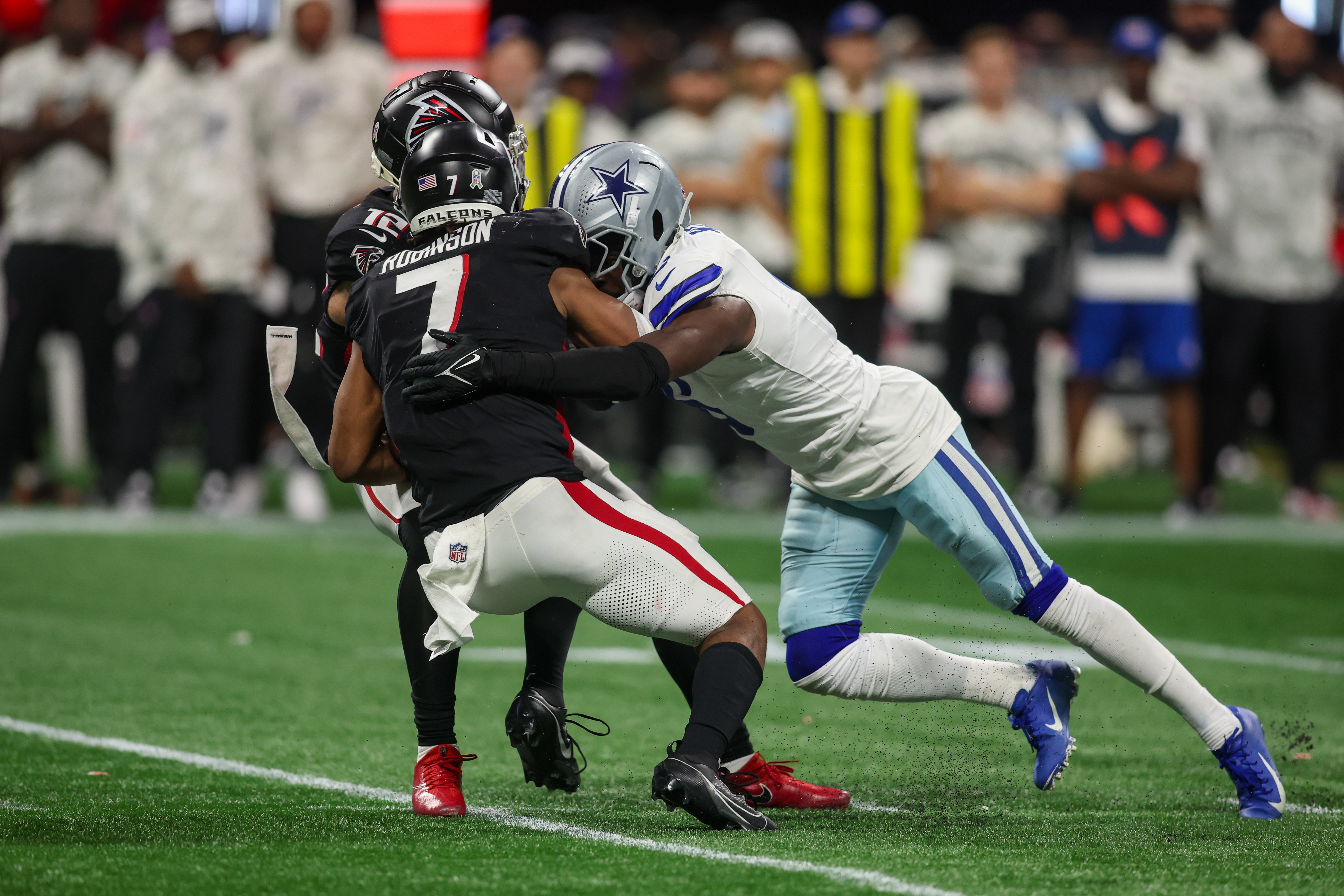 Atlanta Falcons running back Bijan Robinson (7) is tackled by Dallas Cowboys safety Donovan Wilson (6) in the fourth quarter at Mercedes-Benz Stadium.