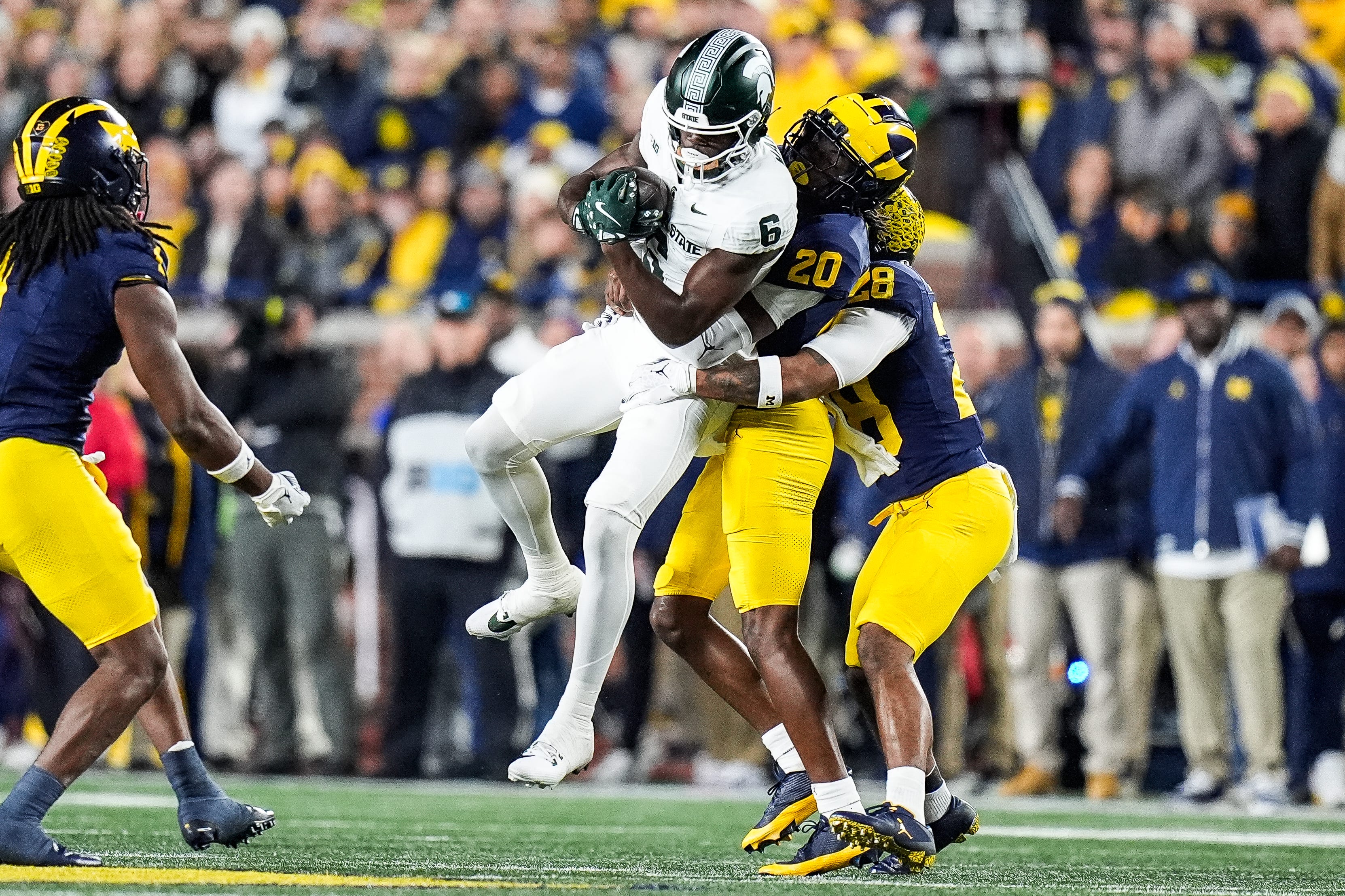 Michigan State wide receiver Nick Marsh (6) makes a catch against Michigan defensive back Jyaire Hill (20) and defensive back Quinten Johnson (28) during the first half at Michigan Stadium in Ann Arbor on Saturday, Oct. 26, 2024.