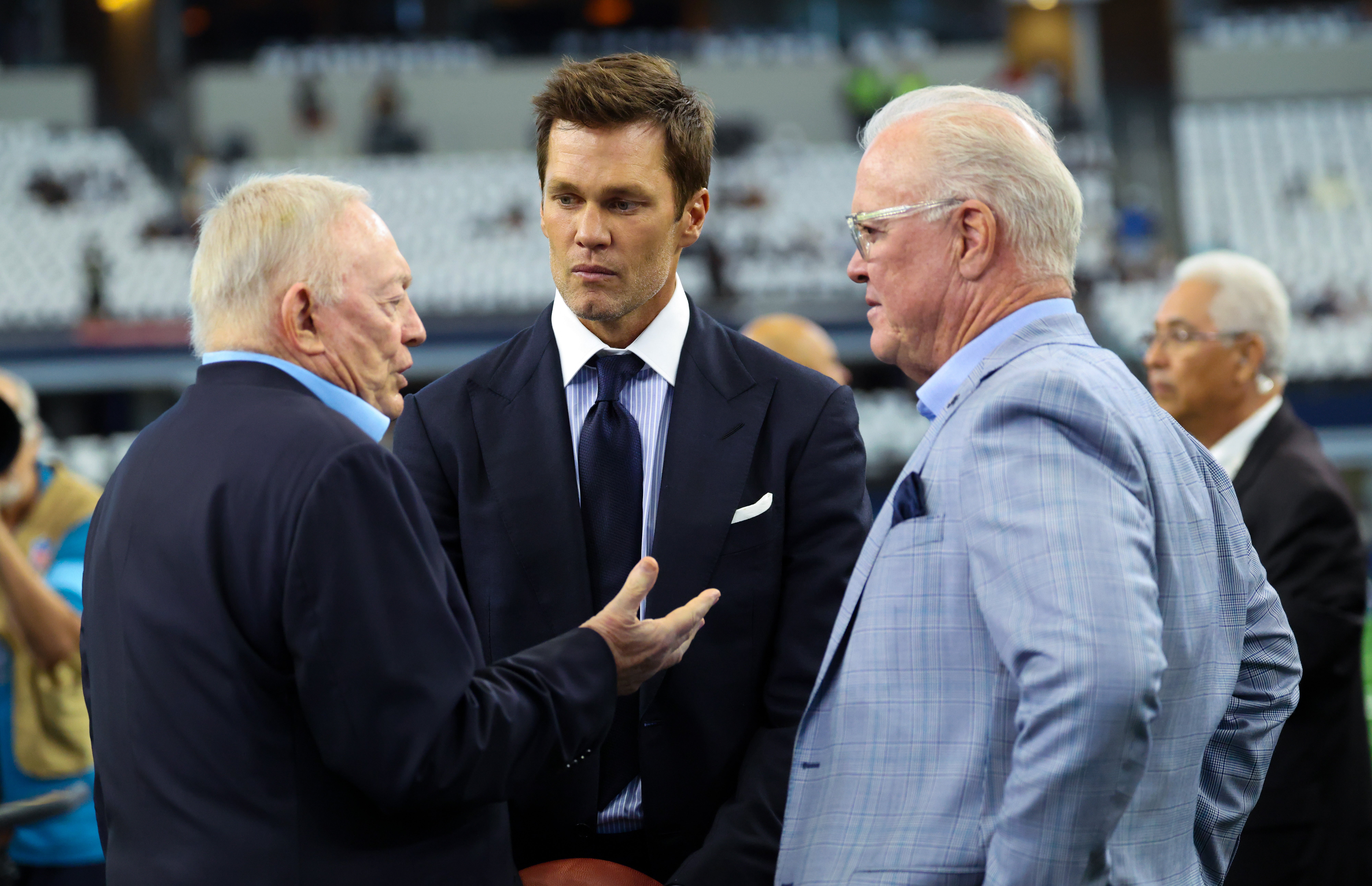 Fox Sports commentator Tom Brady speaks with Dallas Cowboys owner Jerry Jones and CEO Stephen Jones before the game against the New Orleans Saints at AT&T Stadium.
