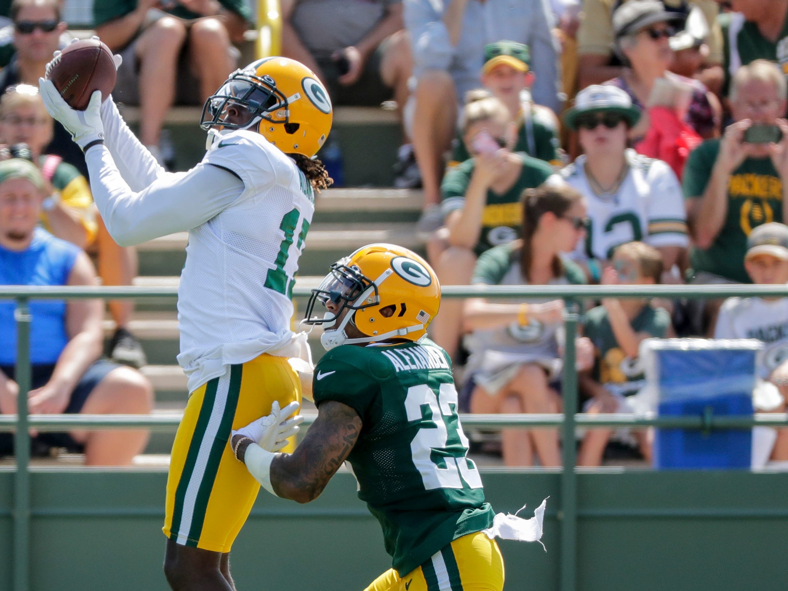Wide receiver Davante Adams (17) catches a pass over cornerback Jaire Alexander (23) during Green Bay Packers training camp at Ray Nitschke Field Wednesday, July 31, 2019, in Ashwaubenon, Wis.