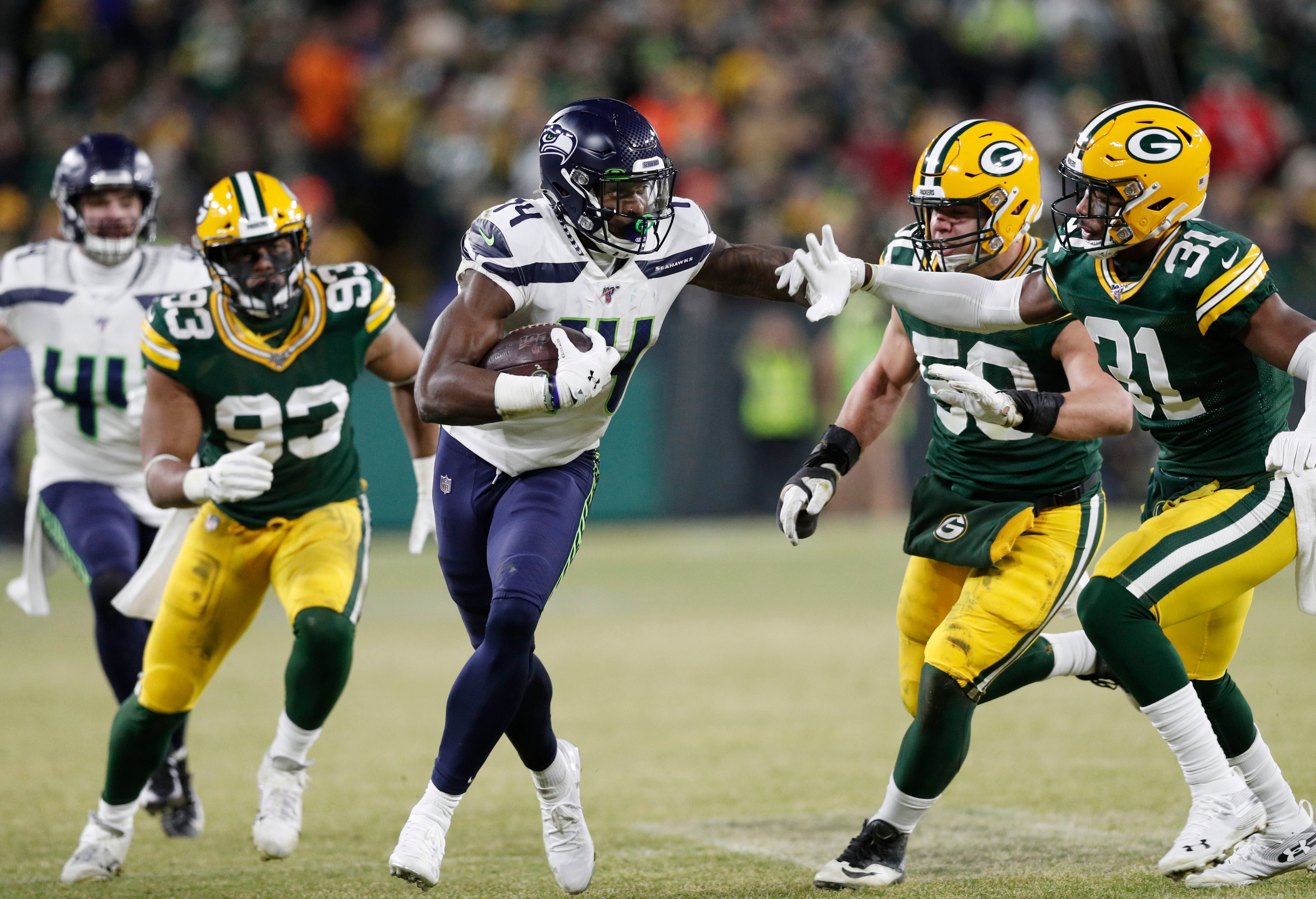 Seattle Seahawks wide receiver D.K. Metcalf (14) tries to get away from Green Bay Packers strong safety Adrian Amos (31) in the third quarter of a NFC Divisional Round playoff football game at Lambeau Field.