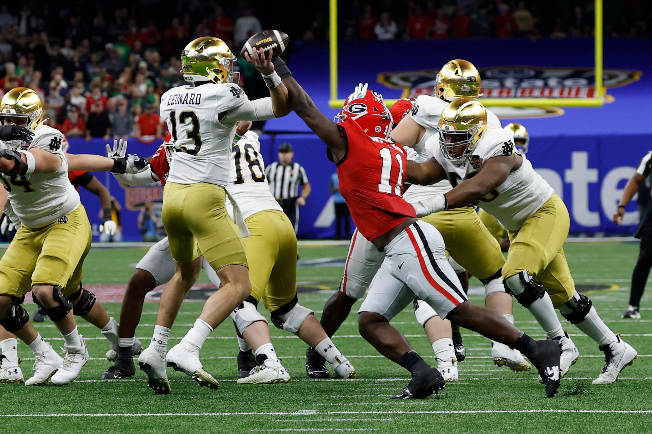Notre Dame Fighting Irish quarterback Riley Leonard (13) passes the ball as Georgia Bulldogs linebacker Jalon Walker (11) defends during the first quarter at Caesars Superdome. 