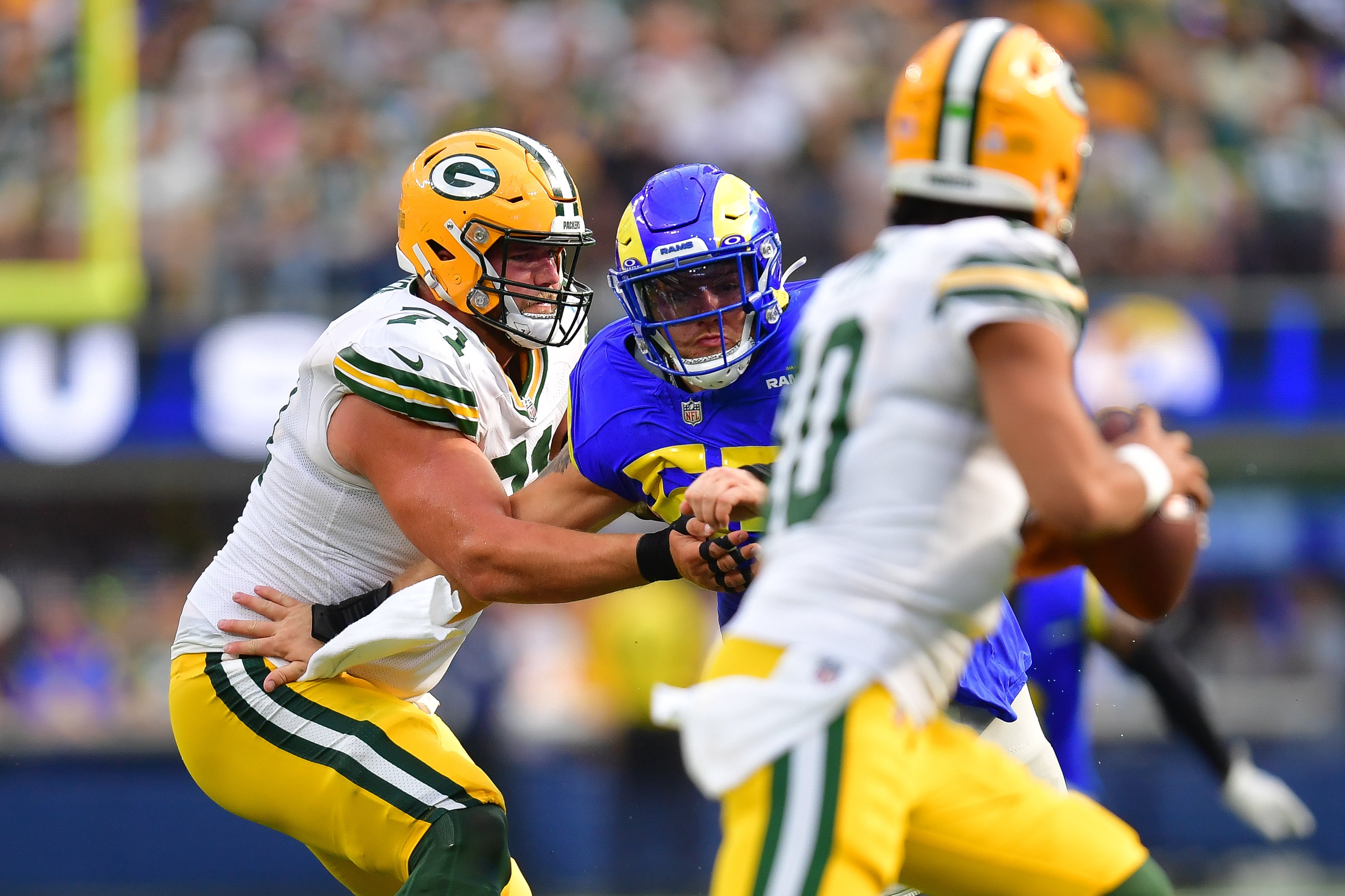 Los Angeles Rams defensive tackle Braden Fiske (55) moves in against Green Bay Packers quarterback Jordan Love (10) as center Josh Myers (71) provides coverageduring the second half at SoFi Stadium.