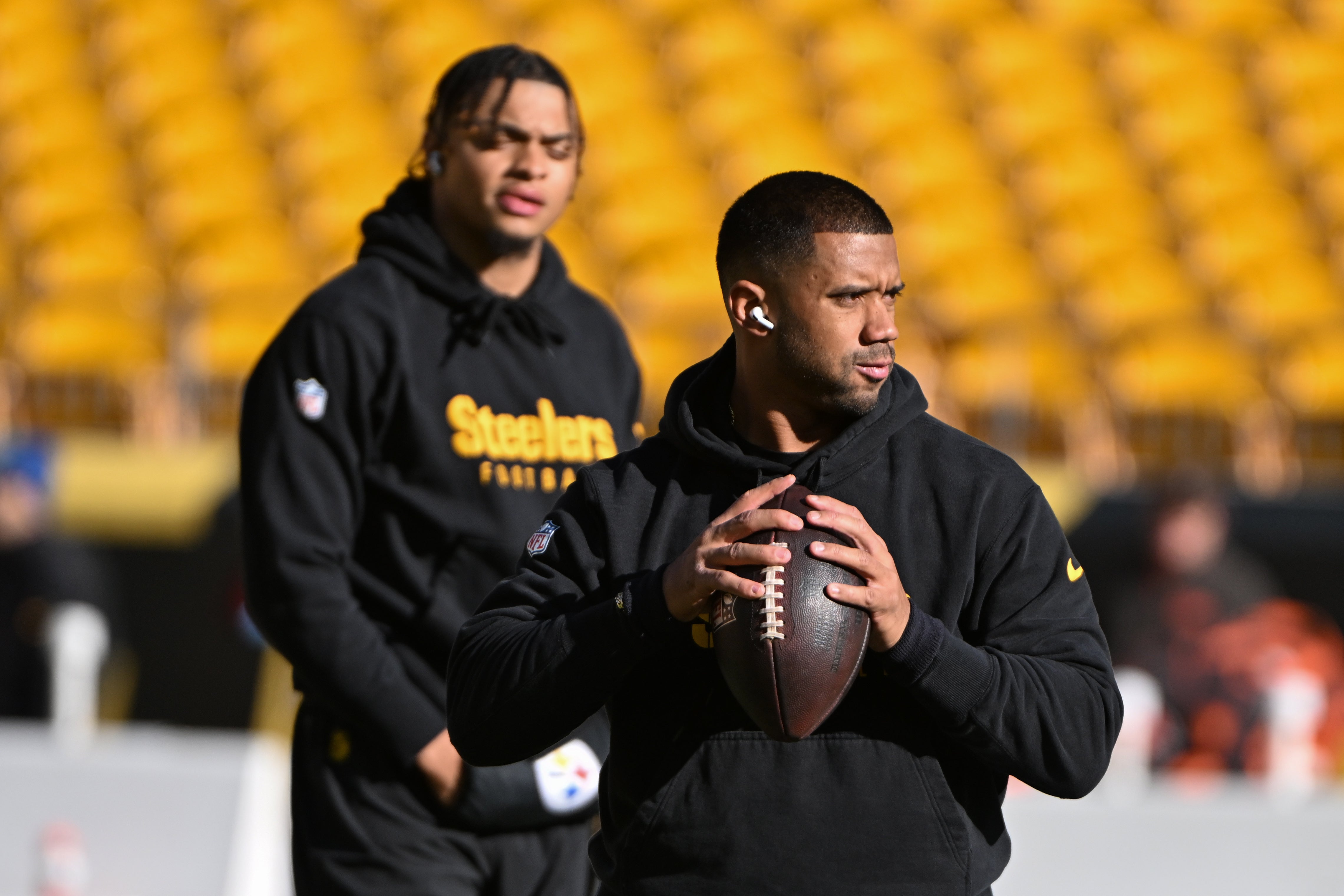 Dec 8, 2024; Pittsburgh, Pennsylvania, USA; Pittsburgh Steelers quarterback Russell Wilson throws the ball as Justin Fields looks during warm ups for a game against the Cleveland Browns at Acrisure Stadium.